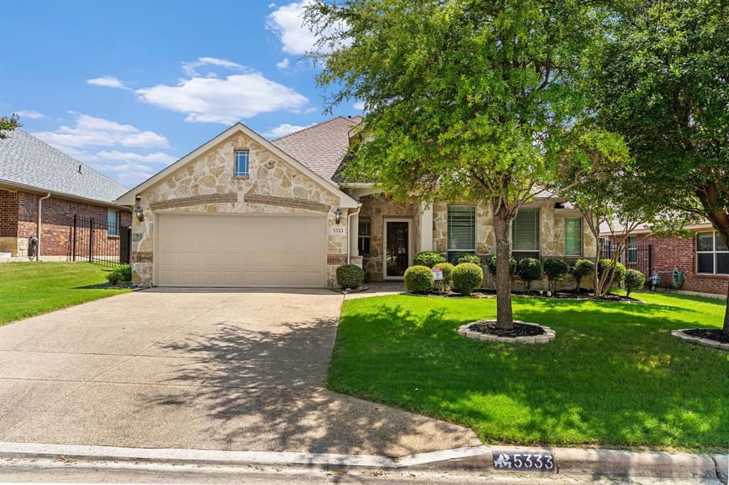 Welcome to 5333 Smokey Ridge Drive, a meticulously maintained single-story home with charming stone accents and an inviting rotunda entry. The open-concept layout is ideal for everyday living and entertaining, featuring a light-filled eat-in kitchen with abundant counter space and a spacious island. The oversized primary suite is privately situated at the back of the home. Step outside to a custom garden oasis, where an extended patio overlooks a peaceful, park-like backyard—perfect for relaxing or hosting guests. Enjoy access to the nearby community pool, plus convenient proximity to highways, shopping, dining, and entertainment.
