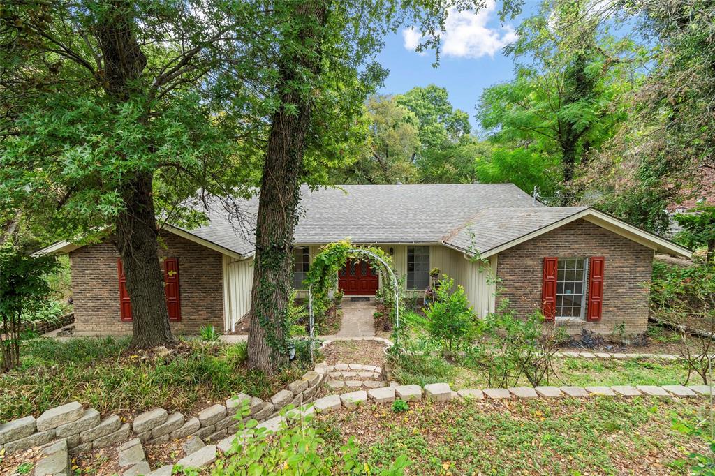 Nestled on a half acre in one of Duncanville's most sought after neighborhoods, this custom-built home rests in a natural setting with mature trees and a seasonal creek. The wood deck offers the perfect spot for relaxation and outdoor entertaining. Inside, the home features a cozy yet elegant design, making it perfect for anyone seeking both comfort and style. Through the arched entry hall, the spacious living room with open beam cathedral ceiling has a beautiful brick wall fireplace. A cozy den with built-in hardwood bookcases leads through french doors to the expansive outdoor living space. In the kitchen you will find ample counter and cabinet space, a gas cooktop, and large pantry and utility room. Oversized 2.5 car garage with workbench and wall-mounted and ceiling-suspended storage. Interior is freshly painted, new roof and rainwater drainage system in 2022, new water heater in 2020, and more. This is truly a lovely home with a great floorplan in a beautiful location!