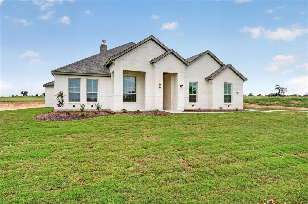 Experience refined country living on just over an acre, where space, style, and freedom come together beautifully. This thoughtfully designed 3-bedroom home with a dedicated study, 2 full baths, and just under 2300 sq ft. offers a highly functional open-concept floor plan perfect for both everyday living and entertaining. The heart of the home is a stunning, upgraded kitchen featuring an abundance of premium finishes, seamlessly flowing into the spacious family room. A striking painted brick fireplace extending to the ceiling, complemented by a rich stained mantle, creates a warm yet sophisticated focal point. Custom built-ins with floating wood shelves add both charm and practicality. Designed with convenience in mind, the home includes a mud bench with a built-in desk and charging station ideal for modern living. Architectural details continue outdoors with cedar posts framing the inviting front porch, along with matching cedar shutters accenting the third bedroom and garage windows for timeless curb appeal. Enjoy the benefits of a NO HOA community and a low tax rate, offering greater flexibility and long-term savings. This property perfectly blends luxury finishes with the peace and privacy of country living, an exceptional place to call home.