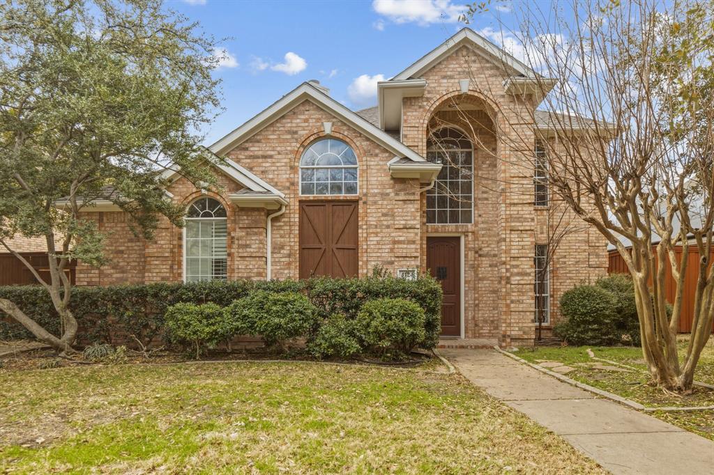 Stately 4 bedroom 2 and a half bath, two story brick and wood trimmed home with custom front door on landscaped lot, rear entry garage with extra driveway parking, wood fenced back yard, plantation shutters, wood floors on first floor, primary bedroom suite carpeted with attached bath with separate tub and shower and two walk in closets and dramatic ceilings. Kitchen equipped with decorator lighting, granite countertops, tile backsplash, refrigerator, microwave, stove, gas range top, disposer, pantry, dining area and second eating area, two living areas, one with a wood burning fireplace. Covered patio area and landscaped back yard. Three bedrooms and bath upstairs with carpeting and extra open living area. One upstairs bedroom features a wall of windows and french doors. Upstairs bath also doubles as a shower. Separate vanity area.