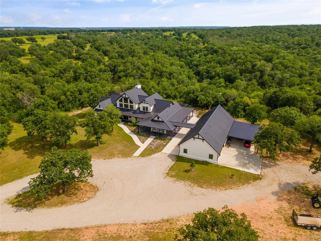 This stunning property encompasses 154 acres of exquisite natural beauty with 6 stock ponds, making it a truly remarkable estate. Nestled within this expansive landscape is a magnificent luxury custom home that exemplifies refined elegance and exceptional craftsmanship.The luxury custom home itself is a masterpiece of architectural design and thoughtful attention to detail. With a spacious floor plan spanning two levels the main floor includes heated concrete epoxy flooring, intricate moldings, and designer fixtures. Equipped with commercial appliances, ample counter space, and a large center island, it provides the perfect setting for entertaining guests. Adjacent to the kitchen is the Family room with grand views of your private setting.The property is ideal for a cattle, horse of various disciplines with a 130X240 outdoor arena. Multiple pastures allow for great land stewardship with native and bermuda grasses. For full Video on youtube go to GS This is Texas Youtube channel.