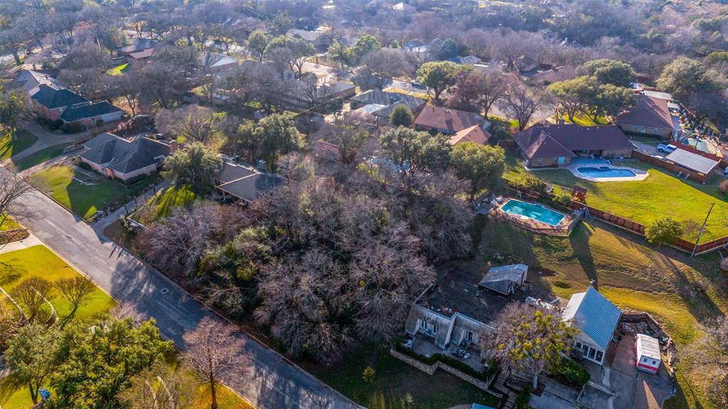 Almost an acre means you’ve got room to breathe and much more outdoor space than typical lots so you can enjoy mature trees, garden area and a pool plus a stunning view of the Trinity River Valley, a rare opportunity in Fort Worth! Extra buildable lot affords options for a second family home or investment, or any extra building space you desire! Still close to restaurants, parks, entertainment, yet feel secluded from neighbors, the extra land gives you space for a playground, fire-pit, outdoor kitchen, or vegetable garden. The ranch-style home offers an open floor plan designed for indoor-outdoor living, large windows overlooking the yard and enclosed sunroom for easy flow to outdoor spaces. With thoughtful upgrades this home can shine and sparkle. The primary suite is split form the seconday bedrooms, great for privacy. A flex room can be used as a formal dining area or office space. The kitchen is open to the living room and breakfast nook, perfect for entertaining or relaxing after a long day. For convenience, the laundry room is spacious and boasts a sink with enormous pantry. The pool and patio area sit tucked against the edge of a wooded landscape, where tall trees form a natural backdrop of green, creating a calm, almost secluded feel. Comfortable lounge chairs and a small seating area invite quiet relaxation, while the soft sounds of rustling leaves and distant birdsong replace the noise of the outside world. The transition from patio to wild woodland feels intentional and serene, making the space feel like a private retreat immersed in nature. Views of the Trinity Greenbelt are yours to enjoy from your higher vantage point. Build your own workshop space, park your RV or boat on its roughly 1-acre lot, bring your imagination and envision your future!