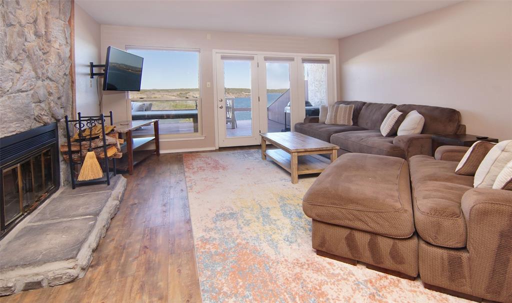 Spectacular Lake View from this furnished 2 bedroom, 2.5 bath, 2 story townhome. Everything you need to start enjoying the Possum Kingdom Lifestyle is included with this property. Downstairs features eat in kitchen with beautiful stone countertops, living area with stone, one half bath, wood burning fireplace, AND a wet bar with mini fridge. Move out the rear sliding door to the deck with Multiple seating options and amazing lake view. Upstairs you will find 2 ensuite bedrooms, 1 of which has a private balcony overlooking Possum Kingdom Lake, and laundry nook with washer and dryer. Located literally around the corner from Bluff Creek Marina for all of your boating needs. This property is an ideal opportunity to experience everything Possum Kingdom has to offer, with lock and leave convenience.