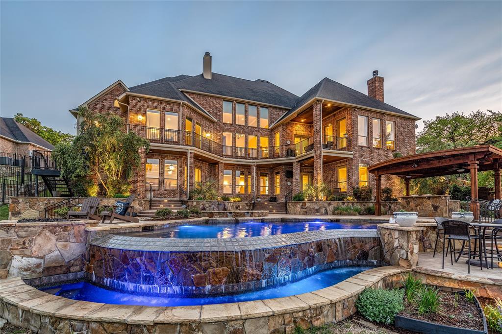 ENJOY INCREDIBLE VIEWS OF THE LAKE FROM ALMOST EVERY ROOM of this stunning executive home WITH LAKE FRONT ACCESS IN DESIRABLE HIGHLAND SHORES! START EACH DAY WITH A BEAUTIFUL SUNRISE! Exquisite interior finish out featuring rich wood with beautiful detailing throughout. Spacious living areas with tons of built in cabinetry & custom finishes. Gourmet kitchen with granite, double ovens, built in refrigerator, 5-burner gas cooktop, large walk in pantry, & gorgeous brick wall surround. Luxurious master suite with private access to outdoor balcony. Huge bedrooms all with walk in closets & en-suite baths. Enjoy direct access to miles of lakefront & wooded trails from this backyard oasis featuring multiple areas for entertaining including infinity edge pool, spa, outdoor kitchen, both gas & wood fire pits, & so much more. This home is made for both entertaining & everyday living, with plenty of space & fabulous views! Impeccably maintained.MUST SEE TO FULLY APPRECIATE THIS REMARKABLE HOME!
