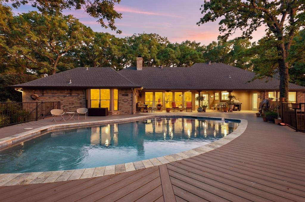 Tucked away on a quiet cul-de-sac street with no HOA, this beautifully maintained one-story home offers the perfect blend of privacy, comfort, and outdoor living on a picturesque one-acre lot in award-winning Carroll ISD. Surrounded by mature trees and backing to Corps of Engineers land, the property features breathtaking views from every window and a peaceful setting enhanced by a small creek running alongside the property.
Designed for entertaining, the home offers 4 spacious bedrooms, 3 full bathrooms, and 2 oversized living areas with flexible space for gatherings and everyday living.  Recent updates include replaced windows, 1 brand new HVAC unit, fresh paint, some new carpet, a recently updated pool and decking, and a brand new hot water heater.  Step outside to enjoy the resort-style backyard oasis with sparkling pool, abundant privacy, and serene natural surroundings.  A detached workshop with electricity provides endless possibilities for hobbies, storage, or workspace needs.  Conveniently located with easy access to major highways, restaurants, shopping, and entertainment, this rare property combines tranquil country-style living with city convenience.