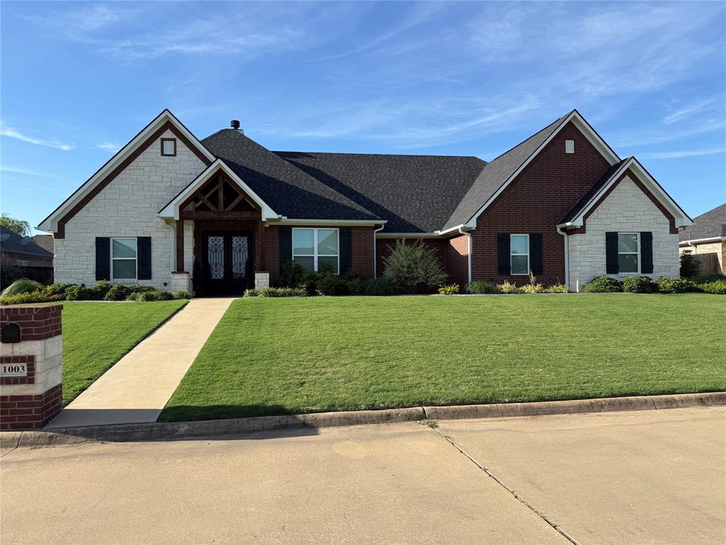 This isn't just a house — it's a statement. A custom-built stone and brick masterpiece sitting on a generous .33-acre lot in Mount Pleasant, Texas, 1003 Stone Bridge St delivers the upgrades and character of an established home with the quality and precision of a new build.
At 3,216 sq ft under roof, the layout is designed to live big. Four bedrooms — one easily converted to a study — and an open-concept floor plan that's made for both laid-back evenings and lively entertaining. And yes, it's located in the highly sought-after Harts Bluff ISD.
The living area flows effortlessly into a kitchen that earns its keep — ample counter space, an oversized walk-in pantry, and a built-in coffee bar that makes every morning feel like a luxury. This is the kind of kitchen you'll actually want to spend time in.
The primary suite is its own world — a spacious bedroom, garden tub, walk-in shower, and not one but two walk-in closets. The additional bedrooms are generously sized, and the flexible study is ready to become whatever you need: home office, playroom, or guest retreat.
Step outside and the story continues. A big backyard ready for outdoor living, gardening, or whatever vision you bring to it. And when those Texas storms roll in? You're covered — literally — with a whole-house generator already in place.
This home checks every box. Schedule your showing today!
