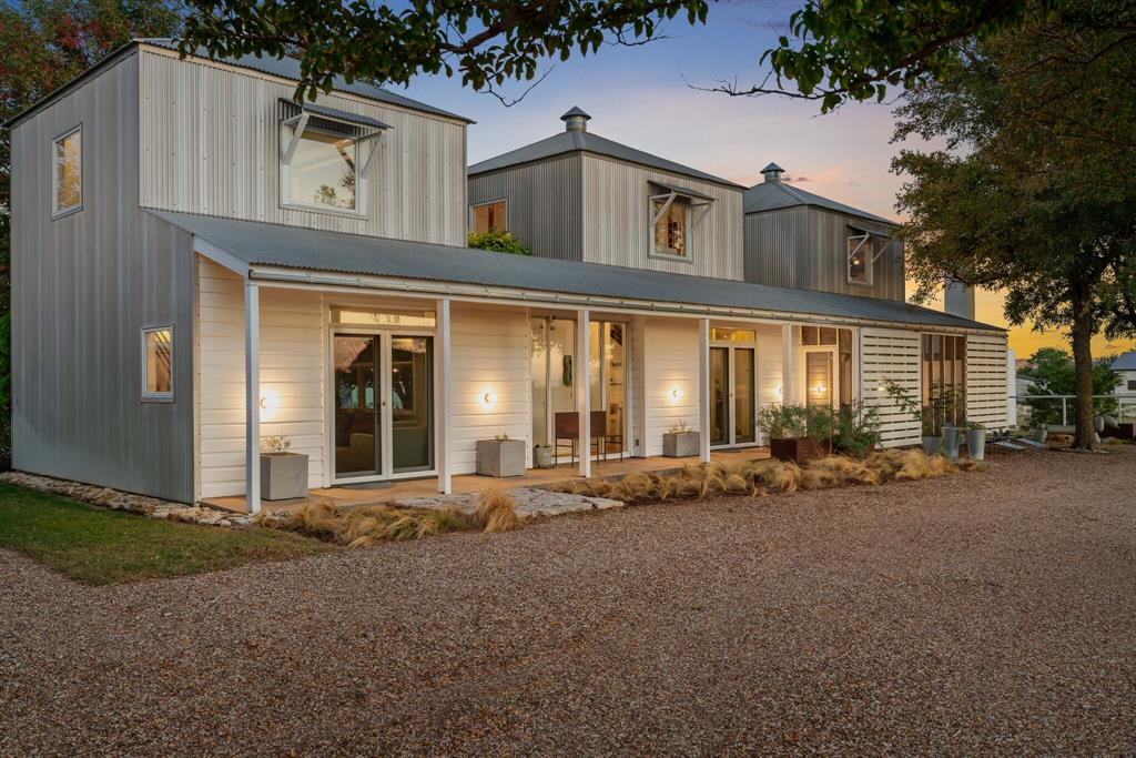Welcome to 2436 Big Sky Trail - an architectural retreat set beneath wide North Texas skies. Designed by award winning architect Max Levy, this Prairie style home rests on an ag exempt, fully fenced 4.65 ac property and has been featured on HGTV and in multiple design publications. Built in 1999 and spanning 2,113 SF, the 3BD, 3BA residence was thoughtfully composed to complement the surrounding landscape. Pella Architect Series windows and doors frame long views of pasture and sky, creating a seamless connection to the outdoors.  The lower level is designed for gathering, bringing the dining, living, and kitchen areas together in an open layout. Stained concrete floors run throughout the main level. The kitchen features crisp white cabinetry with generous storage, a Viking cooktop, and stainless steel appliances. The fireplace anchors the living area and creates a natural gathering point.  Upstairs, bedrooms are arranged as individual suites, offering privacy while maintaining the home’s architectural character. The screened in porch with its own fireplace extends the living space outdoors and provides a relaxed setting to enjoy the land year round.  Beyond the main residence, the property offers additional flexibility. A 312 SF ADU provides space for guests, a studio, or private office with shiplap walls, full cell insulation, mini split HVAC, and custom door and window detailing. The four stall barn includes a tack room, wash bay, electrical, and lighting. Animal shelters, dog run, garden space, and fire pit enhance the usability of the land.  Ponder offers expansive country living just northwest of Denton while remaining within convenient reach of Dallas and DFW Airport. The adjoining 5.26 ac lot is also available for purchase, offering the opportunity to expand to a combined 9.91 ac, build an additional residence, or preserve greater privacy.