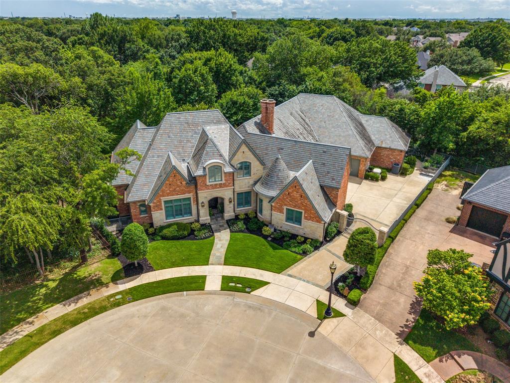 Perfectly positioned on a wooded cul-de-sac lot, this Holmes custom estate offers luxury living with mature trees, lush landscaping, and beautiful backyard views. A grand foyer makes a grand first impression with an iron front door, marble inlay flooring, elegant lighting, sweeping staircase, and detailed ceilings. Rich hardwood flooring, custom millwork, hidden storage, and open living areas create a refined, comfortable setting. The chef-inspired kitchen is designed for serious cooking & entertaining with an oversized Sub-Zero refrigerator, Wolf 48-inch gas cooktop with grill and griddle, double ovens, Wolf steamer, Miele coffee maker, wine refrigerator, refrigerated drawers, ice maker, commercial vent hood, abundant cabinetry, huge working pantry, and additional party storage pantry. The private primary retreat overlooks the wooded backyard and offers hardwood flooring,air jet therapeutic soaking tub, steam shower with frameless glass and bench, and a custom closet with designer storage. The executive media and game room features coffered walls & beam ceilings, projector and screen, blackout shades, wet bar, beverage refrigerator, microwave, built-in cabinetry, viewing bar, and room for a pool table. Upstairs includes a guest suite with full bath, kitchenette with beverage fridge, sitting area, TV hookups,  plus an air-conditioned flex room ideal for a study, gym, or game room. Outdoor living shines with a covered patio, built-in grill, fireplace, seating and dining areas, flagstone walkways, raised garden beds, sprinkler system, and peaceful wooded backdrop. Other features include hard shingle roof, stone & cast stone exterior, commercial gutters, Cummins generator, foam insulation, 3 HVAC units, automated shades, plantation shutters, custom draperies, smart-home technology, holiday light outlets with timers, auto gate, motor court, extended driveway, and dual two-car garages with commercial flooring & extra storage, insulated doors & parking for four vehicles.