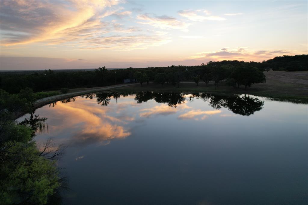 This ranch has it all, rocky outcroppings, sandy soils, grassy areas, thick cover, hunting, fishing, or just relaxing! Entering the gate off Highway 279, you see a bass stocked tank surrounded by scattered oaks & an oak lined ridge in the background. There are 2 other tanks on the ranch, all 3 providing water for livestock & wildlife. There are 7 blinds, 3 bow blinds, & 7 feeders for optimal hunting. The ranch has excellent-good fencing on all sides & is currently holding livestock. Has 2 fully furnished cabins, can sleep 9 people in beds, 2 bathrooms, a covered patio w firepit & a large shop for all the toys.  Some equipment included w sale – JD 4520 Tractor & implements, JD zero turn mower, Kawasaki Mule 2 row seater, Polaris Ranger single row, & much more. For a complete list of equipment, please give us a call.  Brookesmith water supplies the cabins & Comanche County Electric Coop is the electric provider. Don’t miss out on this rare opportunity to own a showplace like this.