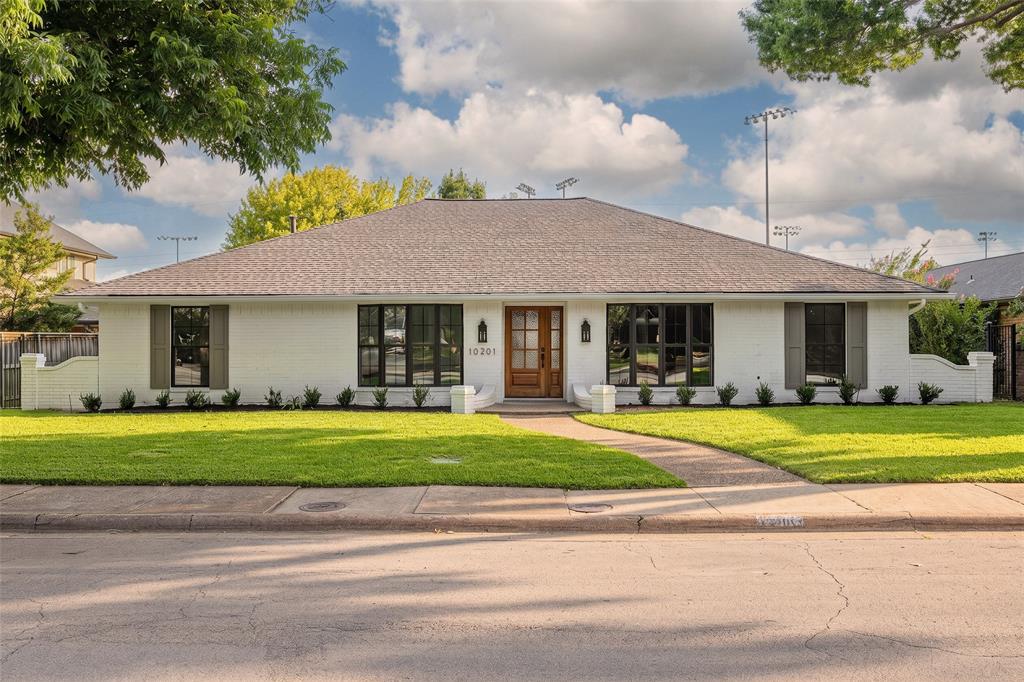 Welcome to 10201 Royal Highlands Drive. Nestled in the heart of Lake Highlands and zoned to Richardson ISD, this beautifully reimagined single-story residence by Maverick Design offers the perfect blend of style, comfort, and functionality.Featuring over 2,100 square feet of thoughtfully designed living space, this home offers four bedrooms, three full baths, an open-concept floor plan, and curated designer upgrades throughout—perfectly suited for today’s lifestyle. Step inside and experience rich engineered hardwood flooring, elevated finishes, and an inviting atmosphere filled with natural light. The expansive living and dining areas showcase soaring vaulted ceilings and a striking fireplace that serves as the centerpiece of the home, adding warmth, charm, and architectural character. Designed for both everyday living and entertaining, the chef-inspired eat-in kitchen features a 36-inch stainless steel gas range, quartz countertops, custom range hood, stainless steel appliances, abundant cabinetry, walk in pantry and stylish finishes throughout. Just off the kitchen, a generous laundry room provides additional storage, convenience and functionality. Privately positioned at the rear of the home, the primary suite offers a peaceful retreat complete with a beautifully updated bath featuring dual vanities, dual closets, designer touches, and an oversized walk-in shower. On the opposite side of the home, the fourth bedroom with an adjacent full bath creates the perfect space for guests, a private office, or a flexible living arrangement. Step outside and enjoy a covered patio overlooking the spacious backyard—perfect for morning coffee, outdoor dining, entertaining, or relaxing evenings at home. A private rear-entry two-car garage enhances the home’s curb appeal while maintaining a clean, classic streetscape. Ideally located just minutes from trails, schools, parks, shopping, dining, and entertainment, this home delivers the best of Lake Highlands living. See it today!