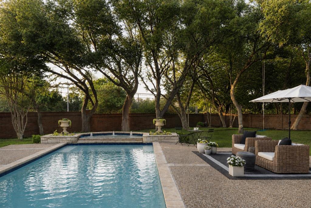 Nestled within the prestigious gated community of Los Arboles, 2 Manzano Circle is a thoughtfully updated estate set on a .62-AC cul-de-sac lot in the heart of Preston Hollow. Located inside this exclusive 24-hr guarded enclave, the home seamlessly blends timeless architecture, sophisticated design, + exceptional privacy. A refined exterior framed by manicured grounds, custom cast stone accents, + classic gas lanterns creates a memorable arrival experience. Inside, the home has been carefully enhanced with elevated finishes + purposeful design thru-out. Rich HW flooring, designer lighting + a newly installed gas range paired with a custom vent hood bring warmth + functionality to the main living spaces. The 1st-floor primary suite serves as a true sanctuary, generously sized + filled w natural light from expansive windows overlooking the lush backyard. The spa-like bath features a steam shower, freestanding soaking tub, dual vanities, a dedicated makeup vanity, + spacious walk-in and cedar closets. A secondary BR on the main level offers remarkable flexibility w custom built-ins, 2 walk-in closets + an updated en suite bath, making it ideal for guests, a private office, or additional living space. Upstairs, 2 oversized BRs each include beautifully renovated en suite baths, while a central landing area provides the perfect setting for a game room, lounge, or study space. An unfinished bonus room presents the opportunity to further tailor the home to your needs, while abundant storage can be found thru-out. Los Arboles, meaning The Trees was originally part of the historic Murchison estate + remains one of Dallas’ most serene + picturesque communities. Mature trees, tranquil ponds + elegant fountains create a peaceful, park-like environment just moments from premier private schools, luxury shopping + fine dining. Combining location, security + timeless refinement, 2 Manzano offers an exceptional opportunity in one of Preston Hollow’s most coveted neighborhoods.