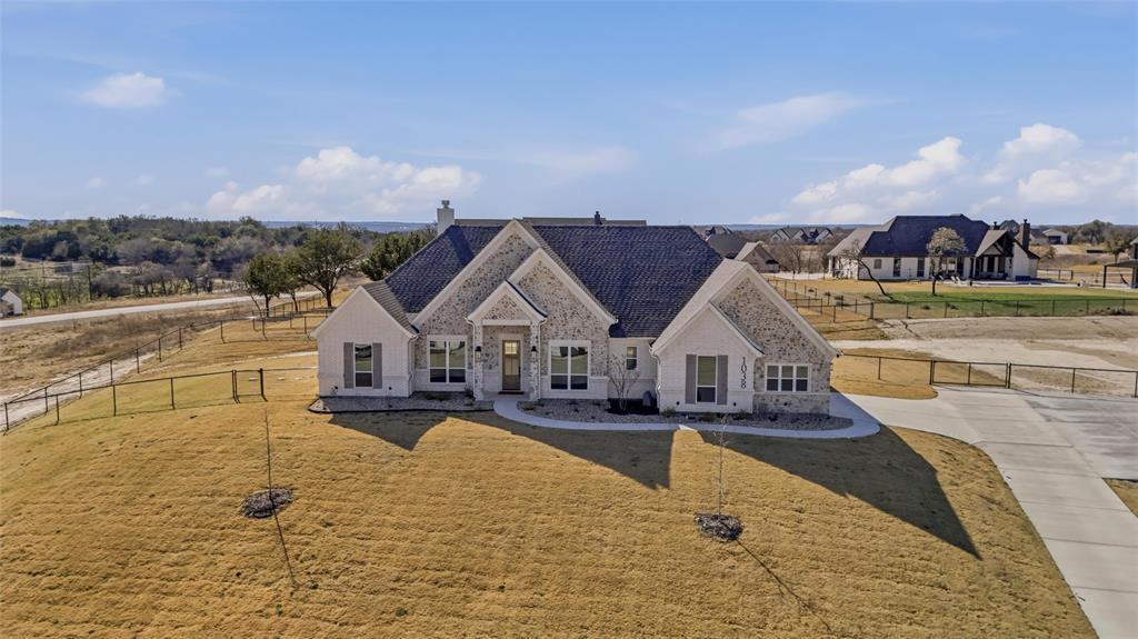 Welcome to a Byron G Custom Home! This stunning new construction home invites you in with an open-concept floor plan and impressive 8-foot doors throughout. Perfectly thought-out finish-outs and upgrades create a luxurious yet comfortable feel. Porcelain wood-look tile flows throughout the main living areas, complemented by designer tile selections in the bathrooms, showcasing the carefully curated design choices found throughout the home. The kitchen is truly a must-see, featuring upgraded custom details including a built-in microwave drawer, electric range, pot filler, and a stylish coffee and wine bar conveniently located across from a large walk-in pantry. Your primary suite offers a clean, sophisticated retreat highlighted by a beautiful freestanding tub. The attached spa-like bath features organic, natural finishes, a separate walk-in shower with seamless glass, dual vanities, and TWO oversized custom walk-in closets. Step outside to take in the stunning Texas horizon views and breathtaking sunsets. The backyard is fully fenced with a no-climb 4-foot fence, 12-foot driveway gate, 4-foot man gate, and the driveway includes a hammerhead extension for convenient turnaround access. Additional upgrades include full spray foam insulation throughout the home and garage, plus epoxy-coated garage floors. The builder provides a 1-Year Workmanship Warranty, 2-Year Systems Warranty, 10-Year Structural Warranty, and 10-Year Foundation Warranty, along with a Warranty Services Plan for the first year. You truly have to see this one in person—your dream home awaits.