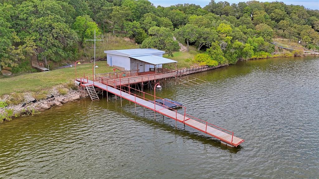 Phenomenal Lakefront Property on Lake Nocona! Rare opportunity to own a high-elevation property with breathtaking views, overlooking the main body of Lake Nocona. Situated on four spacious lots, this unique location offers deep water access, ideal for swimming, fishing, and boating—something hard to find in this area. Located on the west side of the lake, enjoy shaded evenings with the sun setting behind you, making your outdoor spaces more enjoyable year-round. The property includes a private dock and boathouse, perfect for lake lovers, plus a outdoor entertaining area for gatherings, cookouts, and relaxing by the water. Additional highlights, brand new water well, plenty of space and privacy, and stunning panoramic lake views. Whether you’re building your dream home or investing in a lakefront getaway, this is a rare find. The neighboring home is also available MLS#21068568. Opportunity to have properties adjacent to one another! The elevated views of the lake on this property are unmatched!
Excludes: Starlink System, R-low camera, battery pack, dining hutch, Lutron Internet switches, floating jet ski dock, and boat