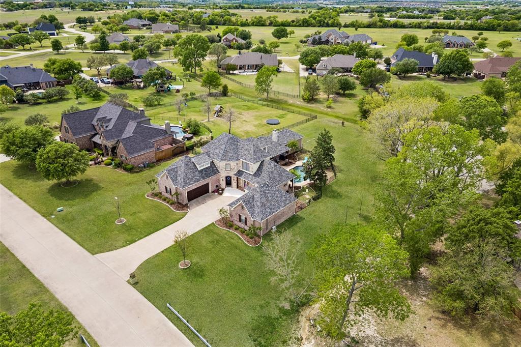 This private home on a one-acre lot in prestigious Morgan Lake Estates offers water views, breathtaking sunsets and recent updates throughout. Rich hardwood floors, a beautifully updated gourmet kitchen with Quartzite countertops, double ovens, oversized cooktop, island, butler’s pantry, and walk-in pantry offer ample prep & storage space for the chef in the family. The thoughtfully designed floor plan features 5 bedrooms, including a primary suite with a completely renovated bath. A private first-floor guest suite with walk-in closet, full bath and connects to the oversized office. This could be a perfect multigenerational living space. Office includes a wet bar, access to single car garage, access the backyard patio & french doors outside to the front of the home. This could be perfect for elderly parents or young adult children. Upstairs includes 3 additional bedrooms, a game room large enough for a pool table, media room with wet bar plumbed for ice maker and drink fridge. A great spot to entertain or enjoy a movie with the family. Step outside to unwind and relax. Enjoy a beautiful Texas sunset while sitting poolside, the breeze causes a rustling of the leaves... all the stress of the day is washed away. Prime the grill on the oversized patio with multiple places to bar-b-que & take in the lush landscaping overlooking the neighborhood pond. Recent updates include appliances, 35+ window panes with transferable warranty, 3 HVAC systems, automated garage doors, Hunter Douglas automated shades, pool equipment, & a climate-controlled garage workshop. This remarkable home combines elegance, comfort, & privacy on one acre minutes to downtown Celina. Coming soon...next door Hillwood Communities is opening a new community that will be adjacent to Morgan Lake with 2 future schools providing numerous walking trails & parks. It will not connect by roadway only walking biking trails.