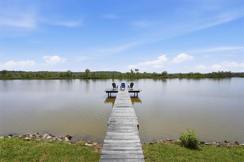 Waterfront living on Lake Granbury with space, shade, and unforgettable views...this one has it all.

Situated on nearly an acre, this beautiful 2,700 sq ft home offers 3 bedrooms and 2 baths with an open-concept layout designed for gathering, entertaining, and enjoying the lake lifestyle. The expansive living and dining areas flow seamlessly, creating the perfect setting for summer nights and time well spent with friends and family.

The upstairs primary suite is a private retreat—spacious and inviting, featuring a beautifully updated bathroom and a walkout balcony overlooking the water with spectacular views.

Step outside and experience what truly sets this property apart. This waterfront lot includes a private dock and is surrounded by mature trees—some nearing 200 years old—creating a breathtaking natural canopy. Multiple outdoor living spaces offer room to relax, entertain, or simply take in the peaceful setting.

This is more than a home… It’s a waterfront escape.