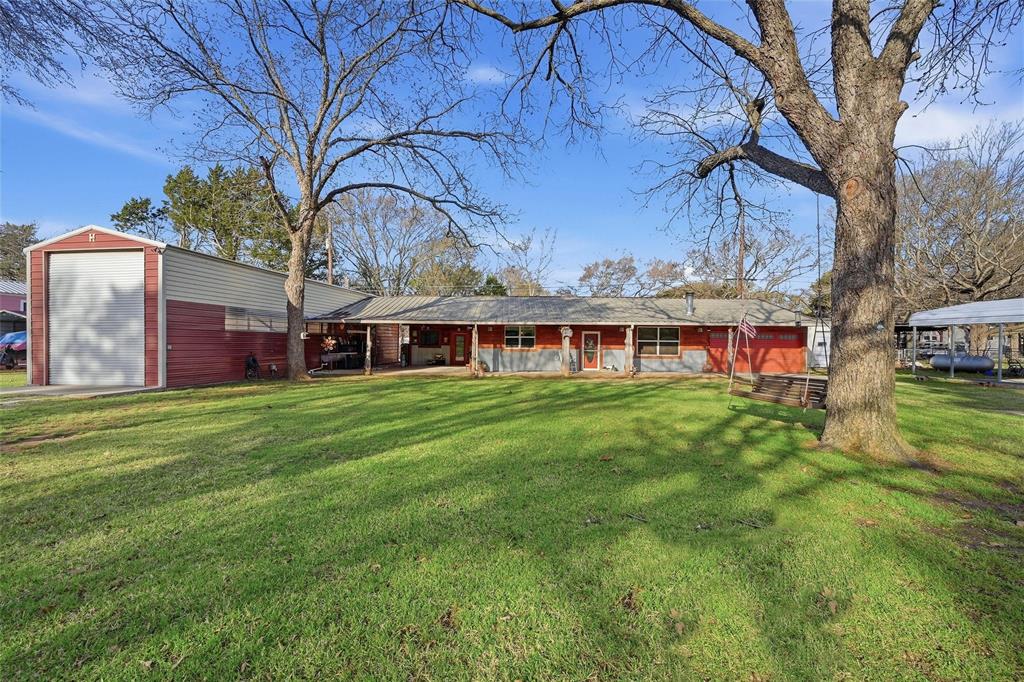 Discover your dream lake home! This 2020-built 2-bedroom, 2-bathroom home features a 16x59 RV shop, a 32x49 shop (both with rollup electric doors), Generac backup power, a storm cellar, heated floors, and a storage building with an attached covered dog kennel (with water hookup). Perfectly situated near Lake Texoma, this property is ideal for full-time living. The home boasts central HVAC and a separate craft room in the garage (with a window unit) that can be used as a bunk area or playroom. The open-concept kitchen and living area are great for winter gatherings, featuring a wood stove. Enjoy warm-weather entertaining in the outdoor kitchen area, accessible from the kitchen and master bedroom. The street-to-street lot layout (4 lots) provides ample access and parking. The master suite includes a walk-in closet with a gun safe, plus a large ensuite bath with a walk-in shower. Furniture is negotiable, and the washer-dryer, refrigerator in the RV garage, living room TV, outdoor kitchen propane stove, outdoor kitchen TV, outdoor kitchen sink, and microwave are included in the sale. The back garage skin and roof were replaced in 2025.