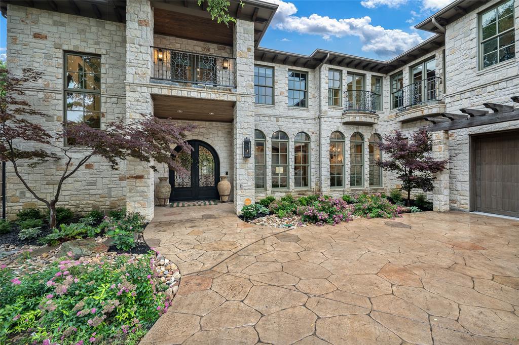 Luxurious country-in-the-city retreat, well-equipped for entertaining. Large heated diving pool with slide, separate spa, and multiple outdoor living areas maximize this double wooded lot. Game room is convenient to the backyard, with a full bath and walk-in wet bar. Kitchen has dual built-in refrigerators, dual dishwashers, double ovens, warming drawer, and Wolf 6-burner gas cooktop. Oversized paneless window provides a picturesque view of the grounds from the kitchen. Master suite accesses balcony, has a wall of windows overlooking the wooded lot, a fireplace, bath with jetted tub, massive shower, dual vanities, and generous closet space. Stone wall and wood beams in family room bring hill country style.