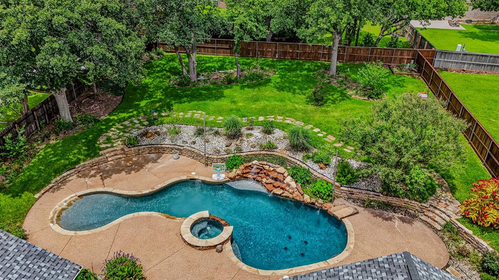 OPEN ENROLLMENT TO CARROLL ISD - Welcome to 2802 Yorkshire Lane, a beautifully upgraded 3,758 sq ft home offering 4 bedrooms and 3 bathrooms on a private 0.54-acre lot beneath mature oak trees in Southlake, TX. Designer finishes throughout include a marble-clad fireplace, chef's kitchen with quartz countertops and navy island, and two spa-inspired bathrooms featuring smart technology, Tahitian glass wallpaper, and opal marble. The primary suite offers a corner fireplace and direct pool access, while a versatile fourth bedroom opens to a private morning porch. A 700 sq ft bonus loft with a home theater adds incredible flexibility. The true showstopper is the custom 42,000-gallon saltwater pool with a walk-in beach entry, heated spa, and natural rock waterfall with a sitting ledge — fully smartphone-controlled. This Southlake address qualifies for open enrollment into Carroll ISD, one of Texas' school districts.