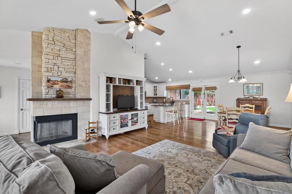 Charming single-story ranch-style home featuring 3 bedrooms, 2 bathrooms, and an inviting open-concept floor plan. The spacious living room welcomes you with a stunning stone-faced wood-burning fireplace that serves as the focal point of the home and seamlessly connects to the dining area and updated kitchen. The kitchen is designed for both everyday living and entertaining, offering granite countertops, a center island, and custom display cabinetry. Beautiful hardwood flooring extends throughout the main living areas, while both bathrooms have been tastefully updated. The generous primary suite features wood flooring, a walk-in closet, and an updated en-suite bath. Secondary bedrooms are well-sized and include ceiling fans and walk-in closets. Step outside to a private backyard retreat complete with a covered patio, cedar awning, lush landscaping, and an expansive slate patio—perfect for relaxing or hosting family and friends. A stained board-on-board privacy fence provides exceptional seclusion. Major updates provide peace of mind, including a recently replaced roof, HVAC pump, whole-home water filtration system, gutters, updated bathrooms, wood flooring, cabinetry, and more. Ideally located near Lewisville Lake, parks, and scenic jogging trails, this home combines comfort, style, and convenience in a desirable location.