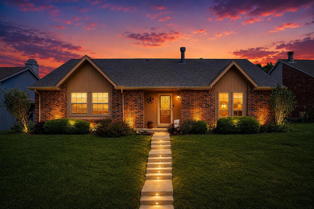 Charming single-story ranch-style home featuring 3 bedrooms, 2 bathrooms, and an inviting open-concept floor plan. The spacious living room welcomes you with a stunning stone-faced wood-burning fireplace that serves as the focal point of the home and seamlessly connects to the dining area and updated kitchen. The kitchen is designed for both everyday living and entertaining, offering granite countertops, a center island, and custom display cabinetry. Beautiful hardwood flooring extends throughout the main living areas, while both bathrooms have been tastefully updated. The generous primary suite features wood flooring, a walk-in closet, and an updated en-suite bath. Secondary bedrooms are well-sized and include ceiling fans and walk-in closets. Step outside to a private backyard retreat complete with a covered patio, cedar awning, lush landscaping, and an expansive slate patio—perfect for relaxing or hosting family and friends. A stained board-on-board privacy fence provides exceptional seclusion. Major updates provide peace of mind, including a recently replaced roof, HVAC pump, whole-home water filtration system, gutters, updated bathrooms, wood flooring, cabinetry, and more. Ideally located near Lewisville Lake, parks, and scenic jogging trails, this home combines comfort, style, and convenience in a desirable location.
