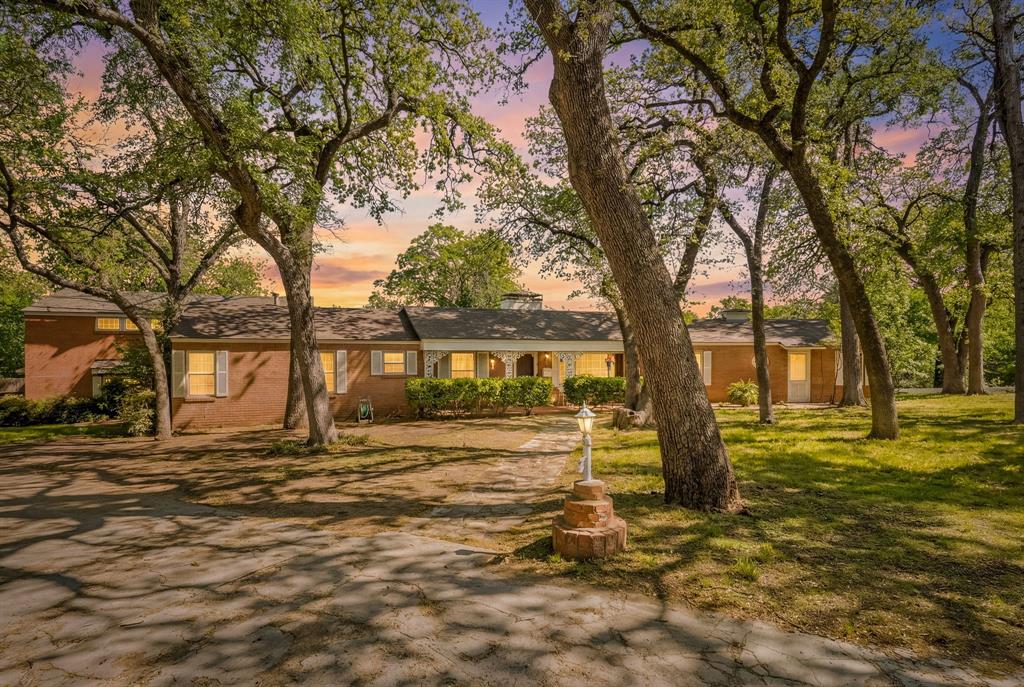 Welcome to this mid-century beauty found in the one and only, historic Oakhurst Neighborhood. When you drive up the hill into the cul-de-sac, you'll be face to face with this iconic home. The driveway goes almost to the back of the 1.3 acre lot where there is ample parking, 3 covered spots and an additional 2 car garage. This 1.3 acre lot is complete with mature oaks, a covered front porch and a massive deck on the back overlooking the cliffside... What a view! From the main entry you will see that everything has been perfectly preserved from the 1960's remodel. A few things that stand out are the oversized windows with a view of the private backyard, the 2-way fireplace, the built in TV and record player, and of course the terrazzo tile floors. When you view the home, please take a moment to look at the downtown skyline from the front yard. The seller is the second owner of this historic piece of art on Smilax Ave and has treated it with care, it's truly exceptional.