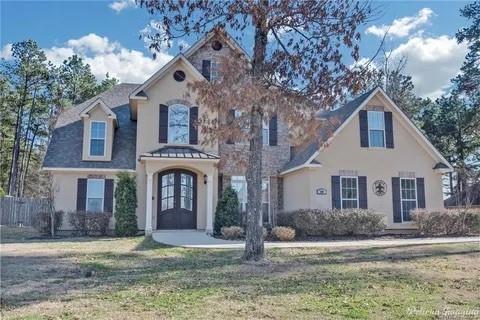 This custom built home with a stunning elevation has all the bells and whistles and is located on an oversized homesite in the prestigious Forest Hills Subdivision. As you step inside, you'll be captivated by high ceilings and a dramatic striking iron staircase. The sprawling layout offers generous room for relaxation and entertainment. The spacious property offers a peaceful setting with a large backyard that backs up to a tree line, ensuring no rear neighbors and plenty of privacy. The heart of the home is the chef-inspired kitchen, which flows seamlessly from the living room and feature granite countertops, a breakfast bar, ample cabinet space and a pot filler. The luxurious primary suite features a spa-inspired bath features double vanities, a custom tile shower and whirlpool bathtub. Also downstairs is a spacious secondary bedroom with an en-suite full bathroom, ideal for guest. There are 3 more bedrooms and a spacious jack- and -jill bathroom with three vanity areas, providing comfort and convenience for the entire household.  All appliances remain with the home as well as security system, sprinkler system. The roof was replaced in 2020, offering the owner a peace of mind. As an added bonus seller is offering a carpet allowance. Come tour your future home today! Comfort, elegance, and functionality await!