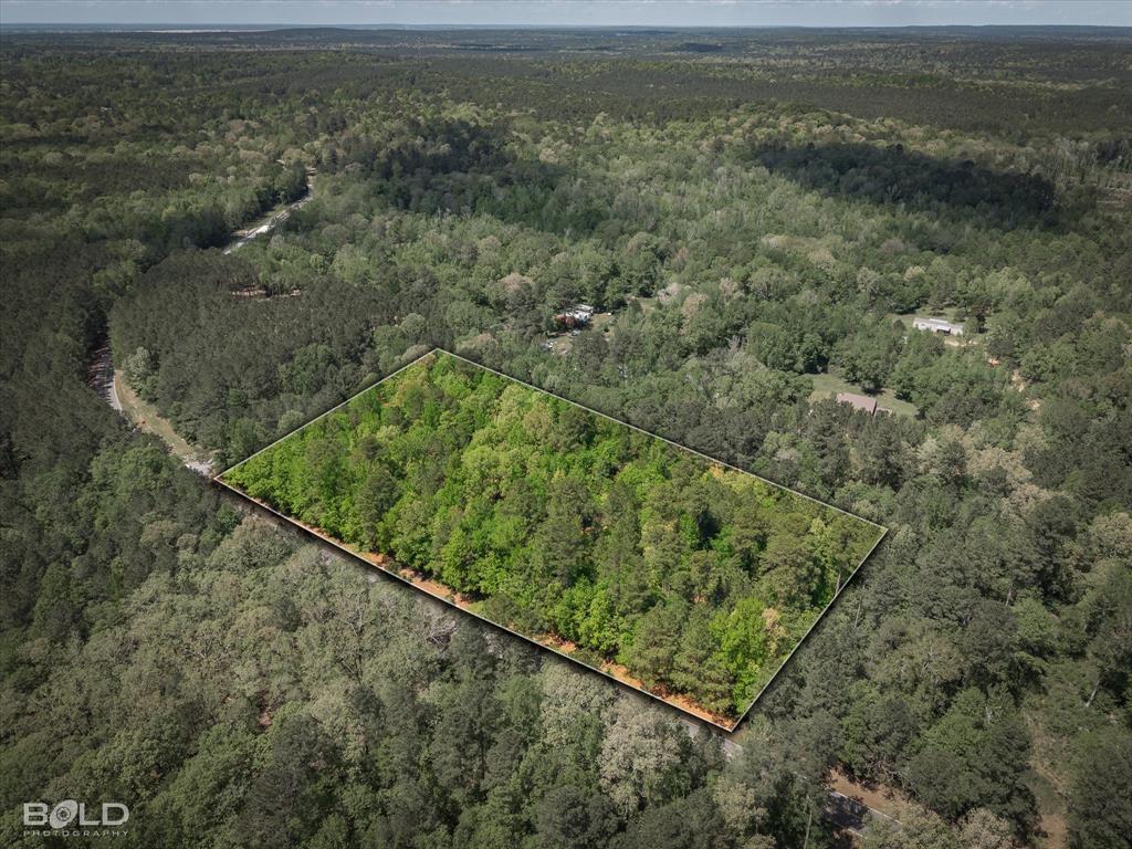 Escape to your own private retreat with this 5.961-acre unimproved land, offering the perfect blend of country serenity and city convenience. Located within the sought-after Benton Schools, this expansive property is a blank canvas with no known restrictions, giving you the freedom to design and build your ultimate dream home exactly how you envision it. The land is densely wooded with many beautiful trees, providing natural privacy and a picturesque backdrop for a future homesite. With 441.74 feet of road frontage, the property offers easy access and a commanding presence. The peaceful feel of country living just minutes from town. Drive by today to see the potential for yourself! A professional survey is available, and survey flags are currently visible on-site to help you easily identify property boundaries.