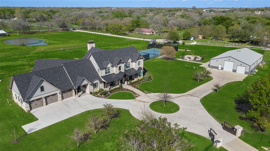 Welcome to 341 Springfield Bend, Argyle, TX - where luxury meets tranquility! This custom-built masterpiece, constructed in 2019, boasts commercial-grade finishes and a contemporary yet charming Modern Farmhouse aesthetic that will leave you breathless. With 5 bedrooms, 4 full bathrooms, and 2 half baths, this home offers an abundance of space for both relaxation and entertainment. The layout is designed with the majority of the living space on the first floor. Prepare to be amazed by the 80 x 50 HVAC Man-Cave, a haven for any enthusiast, with glass doors leading out to the fire grotto and tennis courts. Whether you're hosting lavish gatherings or enjoying quiet evenings, this outdoor space offers endless possibilities for all. Nestled on over 5 acres of picturesque land.