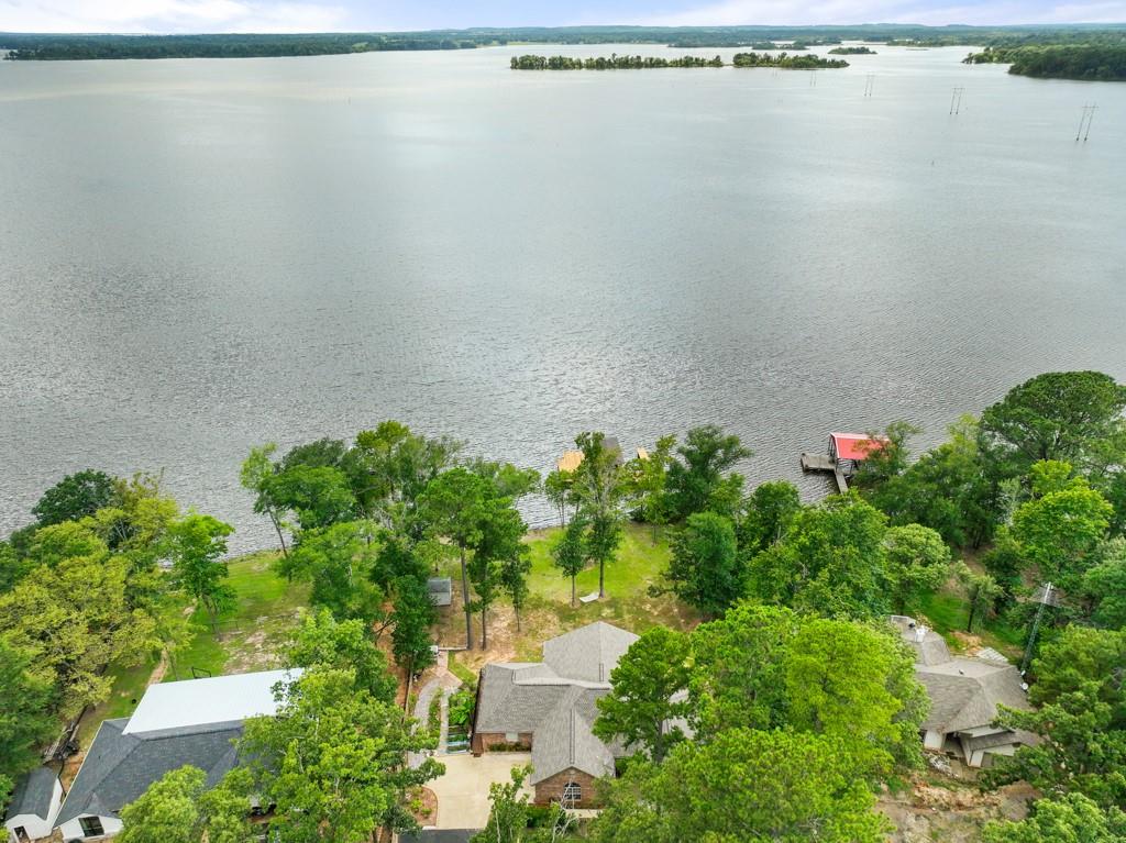 Waterfront property in Hickory Harbor! This wonderful home boasts a BRAND NEW roof, landscaping and MANY UPDATES, such as NEW ROOF, all new paint, luxury vinyl plank flooring, luxury carpet, ceramic tile in bathrooms, marble showers, all updated lighting fixtures inside and out, new patio doors, new decking on boat house, all new plumbing fixtures including low flush modern one piece toilets. Also, the home has a newer HVAC system, on demand hot water and new stainless steel appliances. There is also a spot on the deck for a hot tub! 2 jet ski lifts and 2 boat slips! The split floorplan allows for privacy for guests and the Master Suite, Eat-In Kitchen, Dining and Living Room all showcase the beautiful water of Lake Palestine! Enjoy the more than 600 square feet of outdoor living-entertaining space that will have your guests in AWE! The new exterior lighting package enhances the beautiful outdoor space at night even more! AND the boathouse has been updated as well, including a new roof