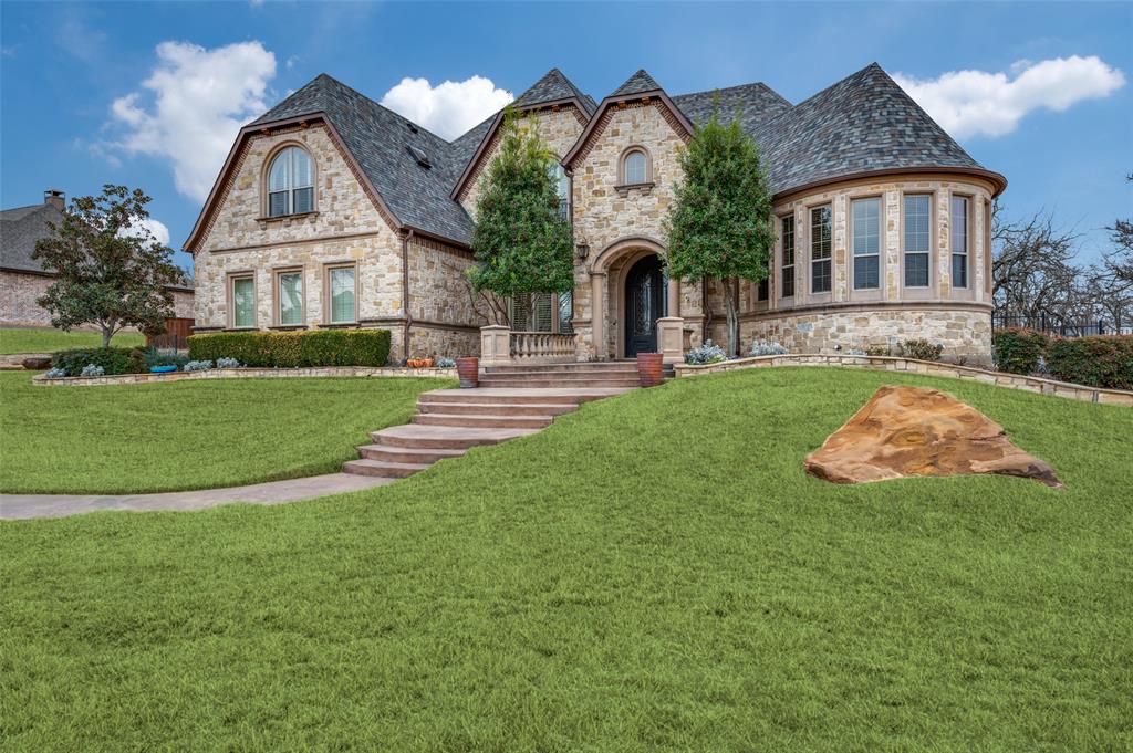 Welcome to this stunning custom home filled with mature trees in The Gates of Waters Edge, an exclusive gated community. It is designed for entertaining in mind as it has a private backyard paradise with covered veranda, outdoor kitchen and fireplace, lush lawn and easy access to Lake Lewisville. The interior features extensive rich hardwood floors and soaring ceilings. The heart of the home is the gourmet kitchen, featuring stainless steel appliances, granite countertops and custom cabinetry. Kitchen opens to family room with stone fireplace, French doors, with walls of windows looking out to the expansive backyard  paradise. The primary suite is spacious and has a luxurious bath with separate vanities and a soaking tub. A guest suite down and dining room with walk in wine storage completes the first floor. Upstairs you will find an oversized executive study with built ins. A large Game room wet bar, Media room and two additional bedrooms that feel like your own private retreat. Minutes from Little Elm Beach Park and boat ramp, central to Frisco and Denton and close to DFW airport.