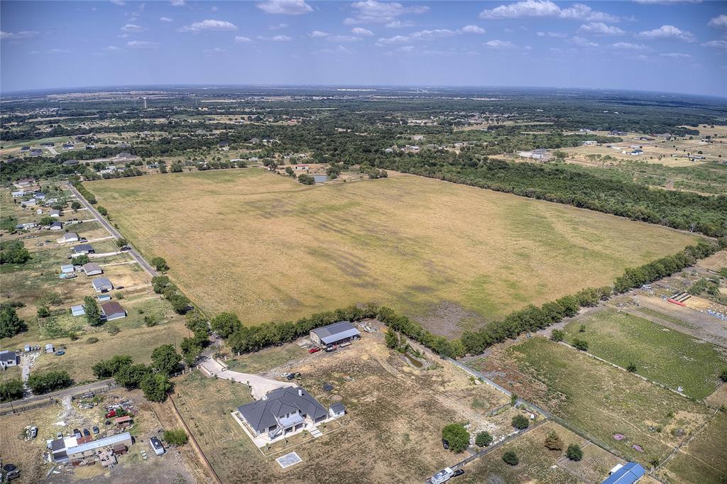 Exceptional Opportunity: 65.5 acres of prime, versatile land across two combined tracts, offering potential for subdivision. This expansive property features a 40x60 workshop equipped with two bay doors, a standard entry, and full utilities including electricity and water. Additionally, it boasts two large barns, fully fenced and cross-fenced for optimal use. A well-lit arena adds further value to this AG-exempt property. Endless possibilities await—bring your vision to life!