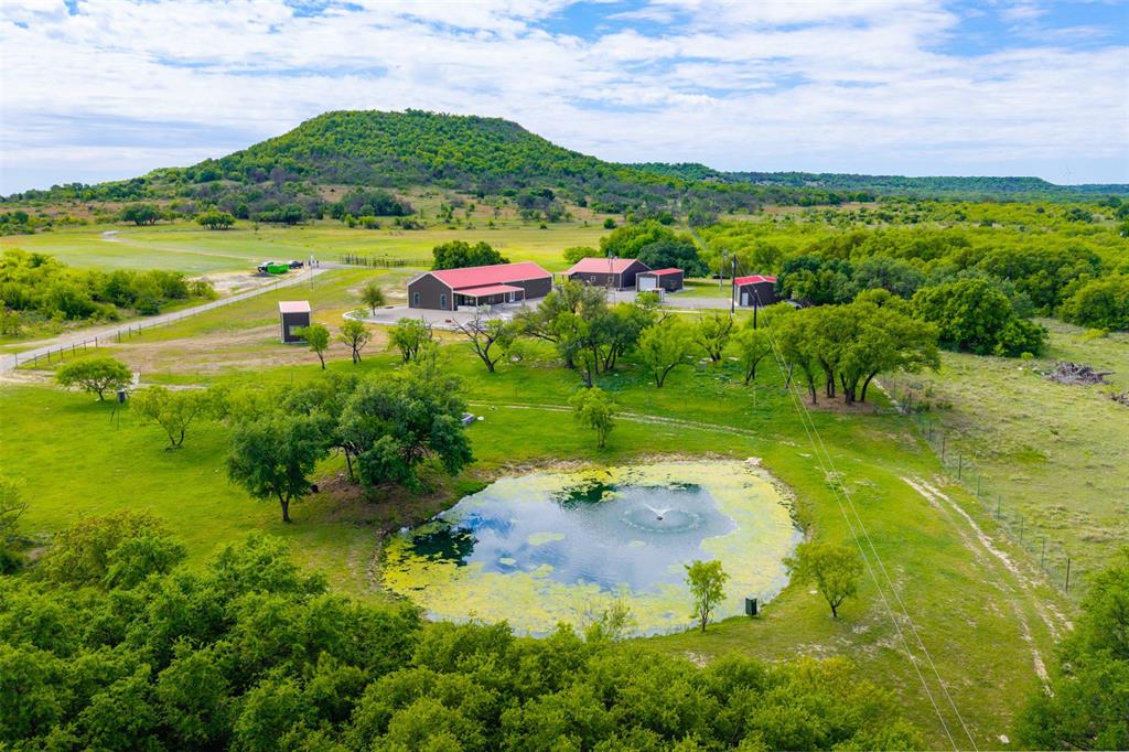 Rockin’ S Ranch is a premier, high-fenced turn-key property just minutes from Comanche, Texas. Set on 235 acres of beautiful, well-watered land and stocked with 14+ species of trophy exotics, this ranch blends luxury living with exceptional recreation. Rockin’ S Ranch is ready for a new owner to step in and immediately enjoy the ultimate Texas ranch lifestyle. The ranch features a luxurious 1,932 sqft, 3-bedroom 2-bath home. Outdoor spaces include a pavilion, barns, and multiple blinds and feeders. A brand-new 100x30 party barn is under construction and will serve as a versatile multi-use space for future owners. This combination of existing comfort and new development creates a turn-key setup with plenty of room to grow. Animals include Waterbuck, Sable, Tahr, Nyala, Oryx, Elk, Buffalo, Kudu, Axis, Markhor, Wildebeest, Blackbuck, Aoudad, and Whitetail with enhanced genetics, along with Rio Grande Turkey and other native game. Equipment included is a 2025 John Deere 520M tractor with a cab and a full set of attachments: 12ft brush hog, 6ft brush hog, 8ft disc, 12ft disc, 2 box blades, root plow, seed planter, bucket, and hay forks. Also included are two zero-turn mowers (2025 John Deere & 2020 Bad Boy), and a 16ft pipe-top trailer with brakes. Multiple protein and corn feeders, along with blinds, are also part of the package, making this a truly turn-key ranch. Water resources on the property are abundant and thoughtfully improved. There are four wells, including a brand-new solar ag well that supplies irrigation and supports the ranch’s water features. In total, there are three ponds, one at an acre in size and two at an acre each, two of which are stocked. A heavily wooded wet weather creek also runs through the property, and two new 2,500-gallon storage tanks provide additional water capacity for irrigation.