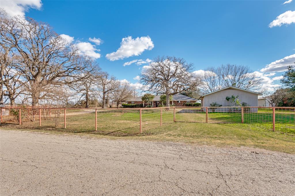 9 Acres, with 2400 sf home for only 510K!  Welcome to a beautiful 9-acre tract, this property offers the peace and privacy of a true rural setting with mature trees surrounding the home. A spacious two-car carport, detached garage that also has a water well inside, and extensive parking areas provide plenty of room for vehicles, boats, and RVs.  Circle drive to for friends and family.  The land is fenced and offers endless possibilities for outdoor living, stock pond for fishing, hobbies, or future improvements. Enjoy quiet evenings on the back patio and deck overlooking the natural landscape.  With a ranch on 1 side and bordering the back the view is awesome.  Inside, the home features a large open kitchen with a center island, perfect for gatherings and meal prep. Two spacious living areas offer flexibility for entertaining or relaxing, and a wood-burning fireplace adds warmth and charm. The layout includes three bedrooms and two full baths, providing comfortable space for family or guests. New aerobic septic system, attached 2 car carport and deck.  A fantastic opportunity to customize and add value in a highly desirable country setting. Just 25 miles from Dallas, rural setting with convivence of access **Buyers and buyer agent responsible for all due diligence duties including verifying all information contained herein, schools, footage, appraisal, hoa, etc. as well as safety of all parties while on property. Water well operation unknown, may need service or pump.