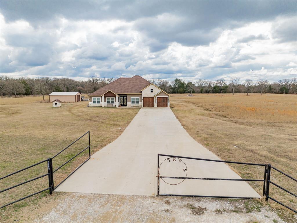 Set behind a gated entrance on 5.82 acres, this 2,458 sq ft home built in 2020 delivers a refined blend of comfort and functionality in the heart of Scurry. The inviting living room welcomes with a fireplace and an open floorplan filled with natural light. A chic eat-in kitchen anchors the home with stainless steel appliances, generous cabinetry and counterspace, and a breakfast bar ideal for busy mornings or casual dining, while the formal dining room is ready for your culinary creations. Enjoy the front-facing home office for a quiet space to inspire productivity and creativity. The ensuite primary bedroom features a vaulted ceiling and spa-style bath with a corner garden tub, separate shower, and dual vanities, complemented by three additional spacious bedrooms and two full baths. Covered front and back porches extend living outdoors to a large entertaining area overlooking a pond and the surrounding rural Texas countryside. Outdoor TV is included in the sale, and this home is complete with a shop, beautiful double front doors. Kemp ISD. This beautiful home offers space, privacy, and a modern country lifestyle just outside the city. Proudly Claim Your Piece of Texas!