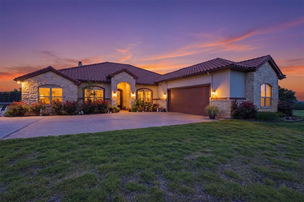 Set on 10 picturesque acres, this stunning estate offers the perfect blend of refined comfort, functionality, and wide-open Texas living. Upon arrival, the beautiful perennials and warm architectural details create a lasting first impression. The land is dotted with beautiful oak trees, a seasonal pond, and a large stone fire pit. Inside, the home welcomes you with an open-concept design, abundant natural light, and elegant finishes. The spacious living area features a striking stone fireplace and seamless flow into the kitchen, complete with rich cabinetry, granite countertops, a large island, bar seating, and a dedicated ice maker. The kitchen also offers a walk-in pantry plus a second pantry, providing exceptional storage. The home includes both a formal dining room and a breakfast room with exceptional views. The primary suite is a serene retreat, showcasing a tray ceiling, generous natural light, and a spa-like ambiance. The en suite bath features dual walk-in closets, with the largest doubling as a concrete storm shelter. Throughout the home, plantation shutters and motorized shades provide both style and convenience. Step outside to your own backyard oasis, where a covered patio with motorized screens allows for year-round enjoyment. The sparkling pool, lush landscaping, and multiple seating areas create the perfect setting for relaxing or entertaining. From the back porch, enjoy gorgeous sunset views stretching across the surrounding acreage. The home is enhanced with decorative jellyfish-holiday lighting, adding charm and appeal year-round. For those needing additional workspace or storage, the property includes a 24x24 metal building with a concrete floor and a 12x21 greenhouse. A spacious attic provides an abundance of easily accessible storage. With expansive open land, scenic views, and thoughtful upgrades throughout, this exceptional property delivers the ideal balance of luxury, privacy, and country living—just waiting to be called home.