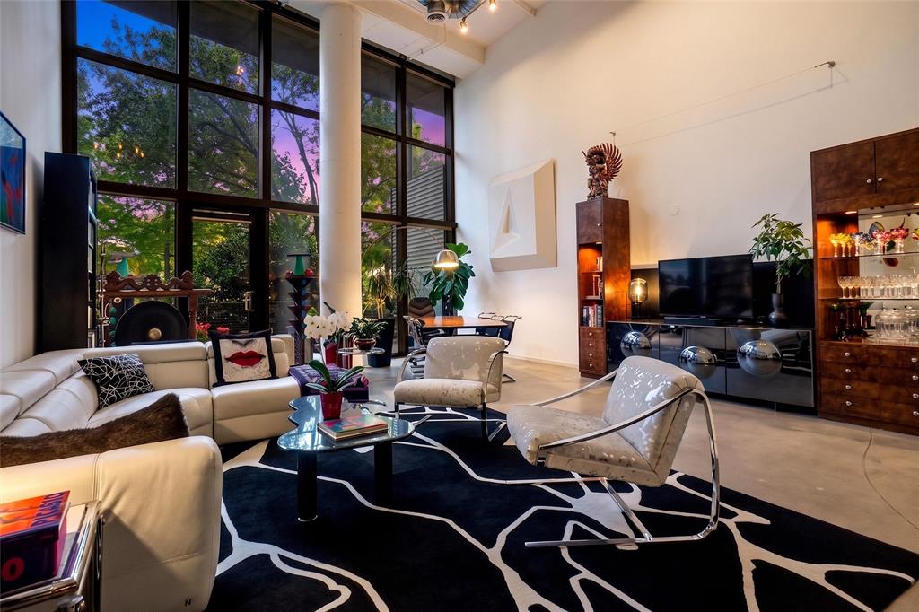Situated in the historically significant State Thomas, Uptown neighborhood, this residence offers expansive vistas through 18 foot high windows, equipped with motorized blinds, into beautiful Griggs Park. In fall, when leaves drop, a panoramic view of the glittering lights of downtown emerges, all of this is a short walk or drive to the internationally famous Dallas Arts District’s Klyde Warren Park, museums, Symphony Hall, Opera House and Theatre. Unit 121 is one of the largest in the building with a party-size balcony. It is surrounded by shrubs and trees as though your private backyard, with nesting birds, squirrels, a heaven for city dwellers and nature lovers alike. The unit has been entirely updated blending industrial with mid-century design.  Its easy living area features an open kitchen with oversized island, extensive custom cabinetry and abundant countertop workspace, invites bar-style and sit-down dining.Off the entry hall, the downstairs bedroom with a large closet has an adjoining bathroom with shower.  Upstairs, the primary, very spacious master suite offers a hi-tech, spa-inspired bath and walk-in closet.  The loft over the living area could be a design studio, home office, media room or yoga area, all with sweeping views into the park.  Entry to the gated premises leads through the landscaped, bricked terrace that is equipped with gas grilles, seating areas and large screen tv.  The fully equipped gym, next to and leading out the back entrance, past a play-pool, exits right into Griggs Park.  On the 11th floor is the Sky Lounge, free use party room for residents.  This condominium complex is in easily walkable proximity of Uptown premier restaurants, grocery stores, and the Katy Trail.  No. 121, is one of the largest condominium units, and has a huge, party-size balcony. It is surrounded by shrubs and trees as though your private backyard, complete with nesting birds, squirrels, for city dwellers and nature-lovers alike, to enjoy.