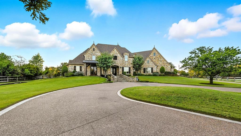 PICTURESQUE 3-ACRE ESTATE WITH A LUSH BACKYARD SANCTUARY, BARN & 4-CAR GARAGE! The foyer welcomes you with a chandelier & flows into a living area with a wall of windows overlooking the backyard & pool. A Texas-style office with Mediterranean flair sits off the foyer, offering French door views of the front acreage. Brick & stone features highlight the inviting feel of the open family room & breakfast area, with a formal dining room for special occasions. Host in the gourmet kitchen featuring freshly painted cabinets, high-end appliances, a gas cooktop, center island with a prep sink, bar seating, walk-in pantry, butler’s pantry & a wine room with an Avanti fridge & space for nearly 200 bottles. Pamper yourself in the lavish primary suite showcasing a double tray ceiling, fireplace & a massive walk-in closet with a chest of drawers, plus a spa-like bath offering a jetted tub with stylish columns, a dual-head shower & separate vanities. Upstairs, enjoy a huge game room with a hidden door leading to a hidden room and a wet bar area, a private media room designed for theater style seating, a balcony with elevated views & three secondary bedrooms.  Drive up from the road appreciating the lush trees & ranch-style fencing that leads to a huge pasture for horses or family exploration. The modern barn with four stalls & a tack room invites horses or any other use on this spectacular property. The backyard is your personal wonderland for quiet time or entertaining, boasting a large saltwater pool with a black stone bottom, an eight-foot deep end, fountain, water feature & spa. A new gas grill & broad space for seating guarantees memories to last a lifetime. Surrounding greenery offers privacy & a getaway from the rest of the world. Fantastic location down the street from Rocky Point Trail, an equestrian trail, with easy access to Lake Grapevine & the popular Northshore Trails featuring 22+ miles for hiking, biking & walking. Click the Virtual Tour link to see the 3D Tour!