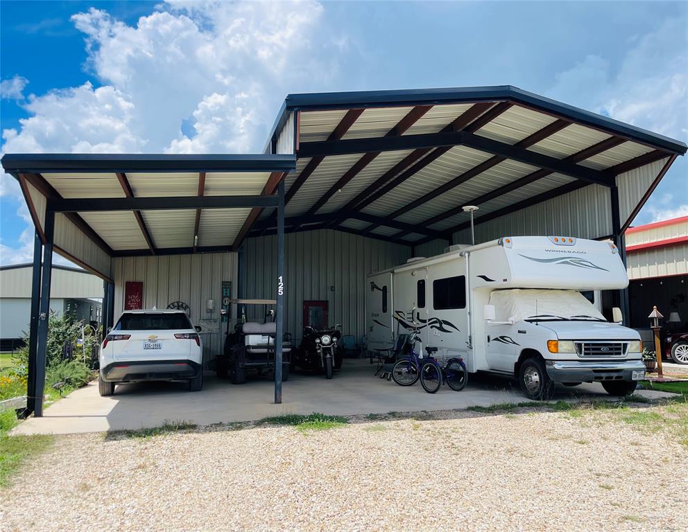 Welcome to your dream retirement retreat in the heart of Whitney, Texas! Nestled within the highly desirable and secure Whitney Resorts 55+ community. This unique one-bedroom, structurally engineered steel and metal barndominium offers low-maintenance living with active resort-style amenities. In addition to the house and storage building, there is also a 50 amp RV hookup with extra covered parking for your travel trailer, boat or other lake toys!
Whether you are looking to downsize or enjoy a peaceful lakeside retirement, this property delivers comfort in a quiet country setting and an unmatched community lifestyle. Enjoy ultimate peace of mind with around the clock controlled security access, relax among scenic, and beautifully maintained landscapes. Just moments away from beautiful water views, fishing, and boating on the lake. Perfect for relaxing, socializing, or staying active during warm Texas summers. Welcome home!