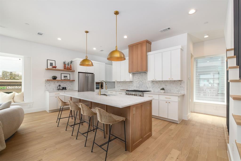 Crafted by the renowned Strange and Sons Development, Cedar Springs Townhomes delivers twenty one modern residences in the heart of Dallas. Interiors are bright and refined, planned for natural light and easy flow. The main level centers on a chef kitchen with white cabinetry, warm wood accents, brass hardware, and Calacatta style quartz on a generous island with an under mount sink. A marble backsplash, brass dome pendants, and a premium stainless package with a six burner gas range, hood, French door refrigerator, built in microwave, and dishwasher complete the space. The great room brings wide plank oak floors, a window seat, and sliders to a private balcony. Upstairs, a spa bath offers dual quartz vanities, oval mirrors, globe lighting, and brushed brass fixtures. The wet room is enclosed in frameless glass and places a freestanding soaking tub inside the shower for a true retreat, with walk in storage nearby. Many plans add a flexible loft for media, office, or guests, with floating shelves and a compact cabinet bar. Outdoor living shines with covered and open balconies, and select homes provide expansive rooftop terraces with a shaded pergola and city views. Architecture is clean and contemporary with strong curb appeal. From this central address you are close to Oak Lawn and Uptown dining and nightlife, the Katy Trail and Turtle Creek Park, West Village, Downtown, the Medical District, the Dallas North Tollway, and Dallas Love Field. Cedar Springs Townhomes pairs elevated finishes, flexible spaces, and a walkable location, with the craftsmanship of Strange and Sons Development.