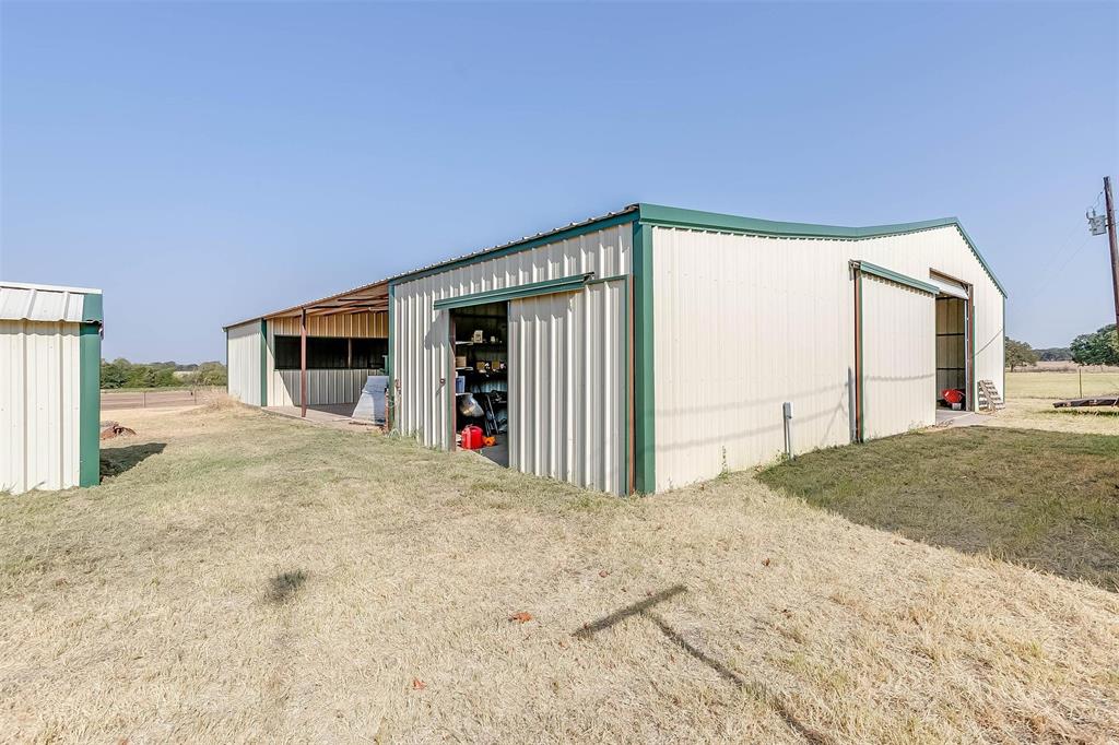 MOTIVATED SELLER SO BRING AN OFFER! This charming 3 bedroom, 2 bath ranch home on 11.32 ag exempt acres has so much to offer! 4000+ sq ft metal barn and workshop combo with electricity and water and plenty of room to park your recreational vehicles, farm equipment or trailers. One end has been designed to be used as a livestock barn with up to 4 horse stalls. Enjoy gorgeous sunrise views in the front overlooking the hay field or amazing sunset views all while sitting out under the pergola. Wildlife is abundant for the nature lover to enjoy! For those who love to garden, enjoy your own greenhouse with electricity and water. Other amenities on this property include a sunroom and a bonus room that is currently being used as a workout room, RV hookup with dump station, stock tank, oversized attached carport and private water well. Stock tank still has water in it in August! Off of the bonus room is direct access to the storm cellar.  Third bedroom does need a wardrobe cabinet for a closet.