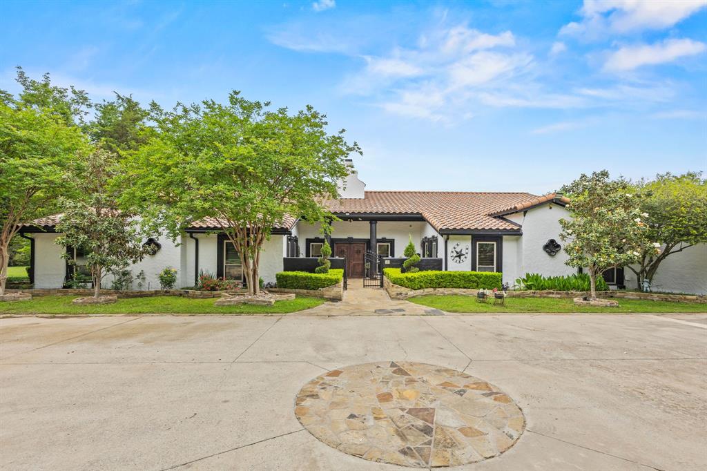 Tucked behind iron gates at the end of a quiet country lane, 41 Graham Lane is a private Mediterranean ranch home on approximately 5.7 acres in the heart of Lucas. Stone archways, a tile roof & warm stucco set the tone the moment you arrive - a home that feels like it has always been here, and was always meant to be yours. 
Inside, more than 4,200 SF unfolds with quiet elegance. Light pours through skylights & tall windows. Hardwood, travertine and slate floors carry you from room to room, and three fireplaces - including a double-sided one & one in the primary suite - anchor the home in warmth. The chef's kitchen is built for everyday mornings and dinner parties alike: commercial-grade range, double ovens, granite island, walk-in pantry & a sunlit breakfast room. Five ensuite bedrooms mean every guest, child & visiting grandparent has their own retreat.
Step outside and the property reveals its second life. A heated pool & spa anchor a resort-style  backyard framed by mature trees, a covered cabana & pool house, where summer afternoons stretch into evenings under the stars. Beyond, the land opens up: pasture, partially wooded acreage, fully fenced & gated, horse-ready with barns and stables in place. A secured warehouse-workshop and additional outbuildings offer rare functionality for storage, hobbies, collectors, or a working studio. With no subdivision restrictions and an optional adjoining 4-acre tract available with separate access from Country Club Road, the possibilities are uncommon: a private family estate, a multi-generational compound, an equestrian retreat, or a combined 8+ acre luxury enclave. 
All within award-winning Lovejoy ISD and surrounded by some of North Texas's most distinguished estate properties. A rare offering where privacy, scale & lifestyle align, place to live well, gather often, and put down roots that last generations.