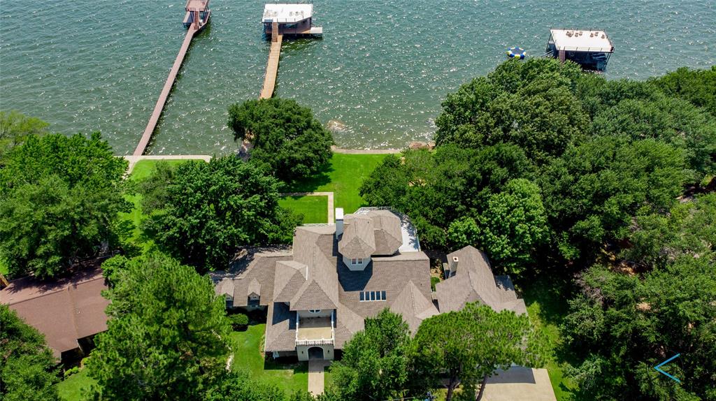 This Coastal inspired home is a landmark on Cedar Creek Lake.  Wonderful Estate setting , mature trees, gorgeous open water and196 feet of shoreline.  Spacious interior with light filled rooms and captivating views at every turn.  High volume ceiling heights, wood floors and plenty of room to gather with two living areas and family game room.  Cooks Kitchen opens to main living , white cabinetry, huge island for eating and serving.  Incredible owners suite with walk out balcony and forever views.  Relax and enjoy the outdoors on the covered porch areas.  Outdoor kitchen with cozy seating around the outdoor fireplace.  Large boathouse is located in deep water, accommodates 2 boats, with additional pwc lifts, and covered sitting area.  Huge party deck is the place to be for the annual Fourth of July Airshow.