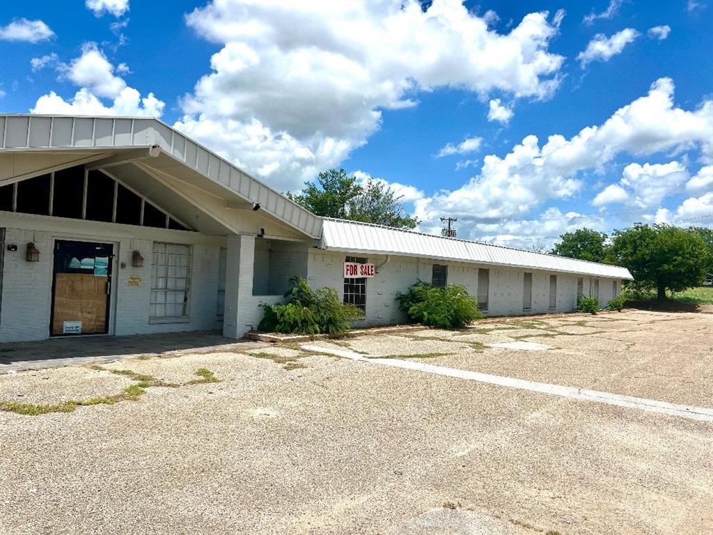 WOW...under $22 per SF, value is in the 3 acres or remodel the 25,000sf building located in North Cleburne.  Zoned Commercial, previously used as a nursing home.  Located close to where the new growth is happening in Cleburne.  Use your imagination...Lots of potential to be remodel and repurpose the building or the land.  Needs a lot of work but for the low asking price and rehab costs, you should be under $100 per sf after all remodeling is complete and the building is beautifully remodeled. It was a former nursing home, large common areas, offices, a kitchen, and 60 rooms, exterior was recently painted light gray.  Each room is equipped with half bath and closet.  Zoned C3 (commercial) can be office or retail, assisted living, office suites, warehouses, self-storage, or a school.  Room to build more behind it on approx 1 acre in back. Close to ballpark...The Depot, and Hwy 67, and Chisholm Trail.  Great location! Go during daylight, no electric. Lots of SF to convert and room to expand...bring your ideas and contractors!