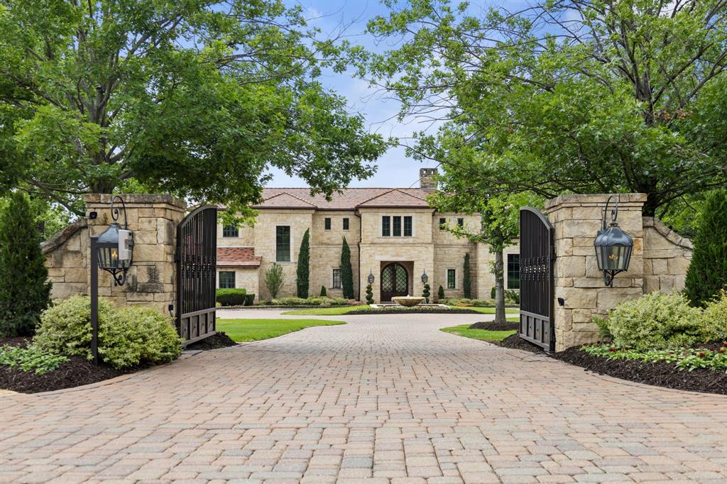 Stunning timeless Mediterranean estate, masterfully designed & built by Jauregui Architect & Builder. Pristinely set on almost 3 private, tree-filled acres, this estate combines the peaceful tranquility of mature native oaks, a babbling creek, natural areas & mature landscaping. Enter through the grand double iron gate to a paver-lined drive + circular motor court centered by a dramatic fountain. Once inside you are greeted with a perfect blend of classic craftsmanship & modern luxury, boasting extensive natural stone, gorgeous custom millwork, exceptional floor plan with curated highest-end finishes. The breathtaking Great room boasts a custom stone fireplace, wood-beamed ceilings, floor-to-ceiling Glass Windows capturing views of Outdoor Living & acreage beyond. The Chef’s Kitchen offers double island layout, Wolf double range w ovens, double full-size Sub-Zero refrigeration w two freezer drawers, Butler’s Pantry + walk-in Pantry.  Designed for both everyday living and entertaining, the 1st level offers multiple living areas including a spacious Game Room, fully equipped Bar, billiards area & game alcove with wall of doors that open to patio + a private executive Study with detailed wainscoting. Retreat from the day to the beautiful Primary overlooking the pool & backyard oasis beyond, with an expansive spa Bath. Spacious, private Guest suite is also down. Upstairs you find 3 Bedrooms suites, Game Room, shared covered balcony, 23'x 23' Fitness room, large storage room ideal for craft or wrapping. The resort-style Outdoor patio spans over 1,400 square feet of covered living, complete with custom fireplace, fully-equipped outdoor kitchen w dual Big Green Eggs, gas grill, bev fridge & built in screens + more. Sparkling infinity-edge pool, spa, multiple fire features, walking paths, private water well, and Tennis Court at rear of the property completes this idyllic resort backyard. Located minutes from DFW Airport & Southlake Town Square.  This is truly a Rare find!!!