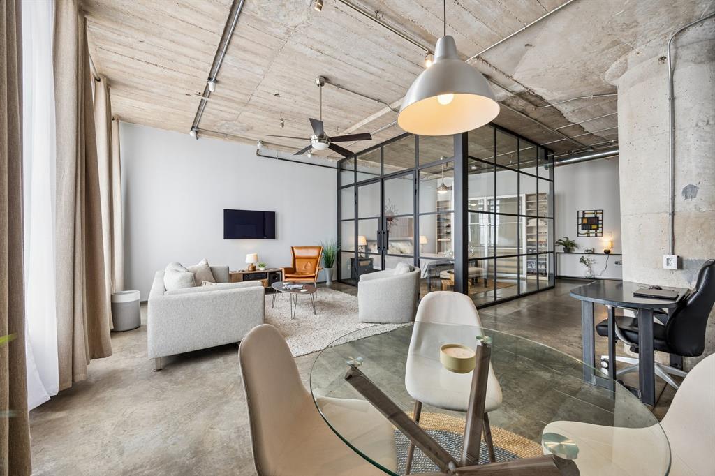 Experience urban luxury at its finest in this masterfully updated south-facing industrial loft within one of Dallas' most iconic historic buildings, perfectly positioned just moments from the vibrant Discovery District. This stunning property effortlessly blends historic character with high-end, contemporary updates to create the ultimate open-concept sanctuary. The centerpiece is a dramatic, floor-to-ceiling industrial steel and glass L-shaped wall. Outfitted with elegant French doors, it frames the dedicated bedroom area to organize the living space perfectly without compromising the bright, open look and feel of the loft. Historic charm shines through in the beautifully restored brick window sills that frame the expansive windows. Updated Kitchen & Workspace:  Fully equipped kitchen with updated Bosch appliances;  Finished with striking, updated soapstone kitchen counters;  Matching built-in soapstone counter top and desk offers a sleek, dedicated workspace and home office station.  Updated Bathroom & Laundry:  The bathroom features new fixtures, including toilet, sink, and faucet;  Enjoy a completely renovated storage alcove and pull-out shelves designed to maximize space and convenience;  A refreshed, dedicated laundry area and cleaning pantry provides ultimate convenience framed in a custom wood shelving system.  Mechanical Upgrades:  Move in with peace of mind thanks to an updated HVAC system and hot water heater for peak performance;  Enjoy ceiling-mounted surround sound satellite stereo fixtures that deliver premium acoustics.  Residents enjoy exclusive access to luxury amenities including a state-of-the-art fitness center, secure garage parking, and a spectacular rooftop pool and grilling facility overlooking the Dallas skyline. Surrounded by acclaimed dining, entertainment, parks, cultural attractions, and the energy of downtown living, this exceptional residence offers the perfect balance of historic character, modern luxury, and urban convenience.