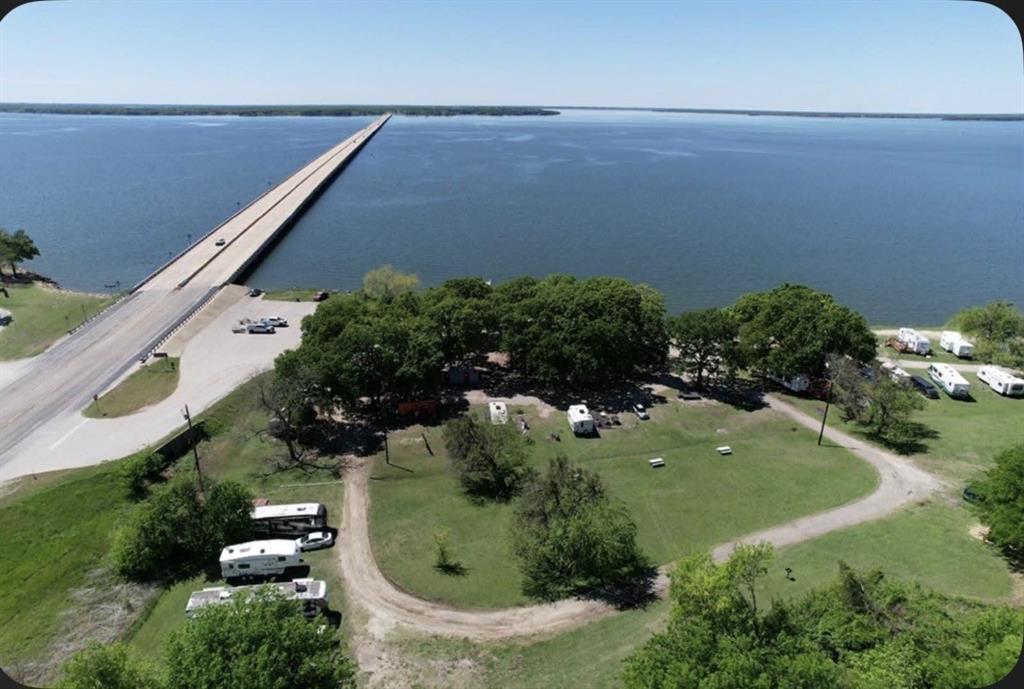 Kenny’s Landing is a rare iconic waterfront landmark and legacy business investment on Lake Tawakoni. The offering includes approximately 38+ total acres: over 10 acres of Sabine River Authority (SRA) leasehold currently operating as a campground and marina, plus an additional 28+ acres of untouched deeded land with frontage on FM 513. Located on the east side of the lake with access from State Highway 276, the property features 35 operational RV pads, each equipped with electricity, water, and sewer. Improvements include a bait shop, fishing dock with a boat-fueling pump (currently not operating), covered picnic areas, a small entertainment stage, public restrooms, parking, and ample room for expansion. Per the owner, the property previously held an approved permit to sell alcoholic beverages. That permit has expired, but the owner believes it can be renewed.

Originally established in 1978, Kenny’s Landing has served Lake Tawakoni residents and visitors for nearly 50 years. It offers a unique combination of waterfront access, existing infrastructure, and significant expansion potential other sites lack. The additional 28+ deeded acres provide flexibility for future development, some ideas are boutique hotel or motel operations, faith-based healthcare or mission-oriented facilities, RV park and marina operations, or other uses subject to buyer verification and approval by applicable authorities. Located roughly one hour east of Dallas–Fort Worth, the property is well positioned for recreational, hospitality, organizational, or investment-minded buyers seeking visibility, access, and long-term upside.

Buyer and buyer’s agent should verify all information, including lease terms, utilities, marina status, permitted uses, development potential, licensing, zoning, and compliance with all local, state, and regulatory authorities. Owner will divide; however, the 10-acre SRA lease area will not be sold before the 28+ acre tract is sold and closed first.