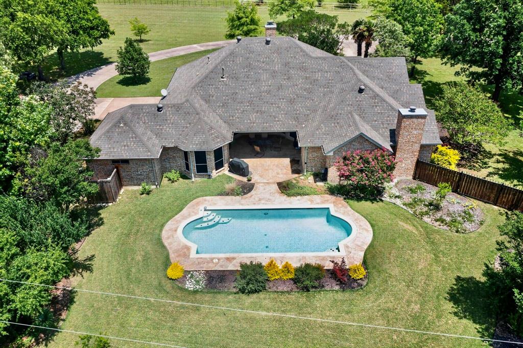 Sitting on nearly 2 acres with a sparkling backyard pool, basketball court & mature landscaping, this impressive property offers unique amenities in a private setting. This single-story home has been thoughtfully maintained & extensively updated over the years, with multiple living & dining areas providing flex space throughout. Front bonus room is perfect for a home office, workout space, hobby room or game room! Previously remodeled kitchen includes a center island with storage & granite countertops, SS appliances (with warranties + double ovens!) & breakfast nook adjacent to the formal dining room. Main living area is light & bright with a central fireplace that adds warmth. Oversized primary suite is complete with bay windows overlooking the backyard & an amazing ensuite featuring a custom cedar closet, separate vanities, updated glass shower & Hollywood bath. Secondary bedrooms also have custom closet storage & easy access to updated full baths. Huge laundry room is a hidden bonus with a glass shower, utility sink, drip-dry area & tons of storage. Step outside to enjoy a private backyard oasis complete with an in-ground pool, expansive patio space (covered + uncovered), mature shade trees, manicured landscaping & nearly two acres of usable land. Wrought-iron fencing (2023) provides privacy around the immediate backyard, while the storage shed, basketball court & sprawling green space offer endless possibilities for recreation, gardening, storage or future improvements like additional structures (ADU, workshop, etc). Major updates include a newer roof (2018), HVAC replacement (2013), dual water heaters (2015 & 2018), kitchen remodel (2013), bathroom remodel (2016), updated windows, whole-home flooring (2012), gutters & guards (2020), repainted exterior (2021) & sprinkler system updates (2024). Beautiful location with no HOA & easy access to Red Oak, Midlothian & Dallas proper, this is a rare opportunity to enjoy acreage living without sacrificing accessibility.