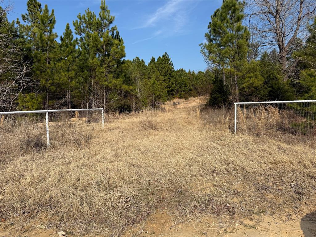 Must see to appreciate all this 5.56 Acers property offers with existing concrete pad covered, water and electric hook-up for RV. Gravel drive and parking apron which overlooks a small pond.  Trees provide seclusion from FM 1255.  Property has nice fence on South side. Unlimited potential bring your RV or build new.
