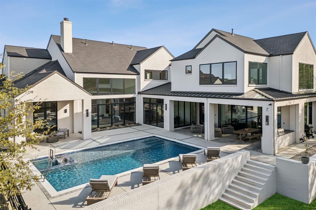 Built by Lewis & Earley, this modern custom home located outside of city limits (Low Tax Rate 1.53%) sits on nearly 2 acres and is situated on a heavily wooded lot in the intimate gated community of Creekeview Estates. Tucked away from the hustle & bustle, this home offers a seamless blend of privacy & impeccable craftsmanship. Effortlessly chic from the moment you enter, white oak floors will lead you through an open-concept layout with breathtaking sightlines, framed by a moving glass wall system, that extends from the main living to the heavily wooded backyard and grand outdoor oasis. Spectacular heated & chilled Mineral Pool & Spa has been designed for unforgettable gatherings with its expansive outdoor cooking & entertaining spaces. Luxurious kitchen impresses with its striking rift-cut white oak built-in china cabinet, 60in Wolf range & paneled Sub-Zero appliances, Arabescato Marble, Negresco Granite countertops & cabinetry adorned with unlacquered brass hardware. Adjoining prep kitchen sports second dishwasher, sink & fridge with access to pantry. Gym buffs will love the state-of-the-art workout studio, which sits on its own climate-controlled system, featuring: rubber flooring, rock climbing wall, 2-story climbing rope, and indoor basketball hoop. Gym studio also has fully integrated sliding glass doors to create a seamless connection to the backyard. Above gym, a glass-enclosed office located on the second story of the main home, providing a dynamic work-from-home environment. Primary retreat, with vaulted ceiling, offers direct access to the mineral pool & features a spa-inspired bath which is adorned with Calacatta marble, limestone floors, deep soaking tub & walk-in rain shower with dual heads. Master walk-in closet offers unparalleled convenience with secondary laundry. All secondary bedrooms feature designer-curated en-suite baths, each showcasing bespoke tilework, luxurious countertops, and high-end fixtures. Large game room up, plus 4-bed bunk room.