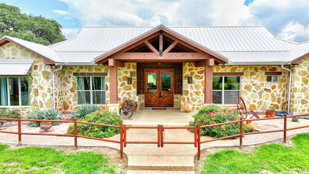 Seller Is Motivated! Luxury Ranch Living On This Equestrian Estate Spanning On Over 75 Acres That Blends Comfort With Beauty. A Gated Entrance Welcomes You Up A Striking Custom Rock-And-Stone Home. Inside, A Grand Entry Flows Effortlessly Into A Light-Filled, Open-Concept Living Space Featuring Vaulted Ceilings, Fireplace, & Expansive Windows That Capture Views Of The Palo Pinto Mountains. The Home Offers 4 Generously Sized Bedrooms, 4 Full Bathrooms, & A Versatile Bonus Room. Designed For Both Style And Functionality, The Gourmet Kitchen Showcases A Farmhouse Sink, Gas Range, Center Island With Bar Seating, & Custom Finishes Throughout. Durable Concrete Flooring Adds A Practical, Ranch-Friendly Touch Across The Home. Equestrians Will Appreciate The Thoughtfully Designed Facilities, Including 2 Horse Barns With A Total Of 19 Stalls—7 Priefert Box Stalls- That Can Be Removed, If Desired, To Use the Metal Barn for Equipment Or Other Needs, 10 Stalls With Runs & 2 Additional Stalls. The Property Is Fully Equipped For A Variety Of Horse Operations With A Full Roping Arena With Boxes, Additional Riding Arena Or Turn Out Area, Tack Rooms, Wash Rack, Holding Pens, Loafing Sheds, Multiple Turnout Pastures, Horse Walker, & Extensive Cross-Fencing. YES, There Is Water With 2 Ponds, A Windmill With A Producing Well, & Co-Op Water Ensuring Reliable Supply For Both Livestock & Daily Living. Outdoor Amenities Include A Covered Patio, Exterior Lighting, RV Or Living Quarters Trailer Hookup, & Ample Parking That Includes A Detached Carport, Oversized Metal Shop Used As A Garage Or Workshop With A Car Lift. A Circular Drive & Gated Entry Provide Both Privacy & Ease Of Access, While The Coastal Pastures & Mature Trees Create An Ideal Setting For Grazing, Recreation, Or Simply Enjoying The Peaceful Surroundings. This Property Offers The Perfect Balance Of Luxury, Functionality, & Texas Charm—An Ideal Retreat For Ranch Living, Equine Pursuits, Or A Serene Countryside Escape.